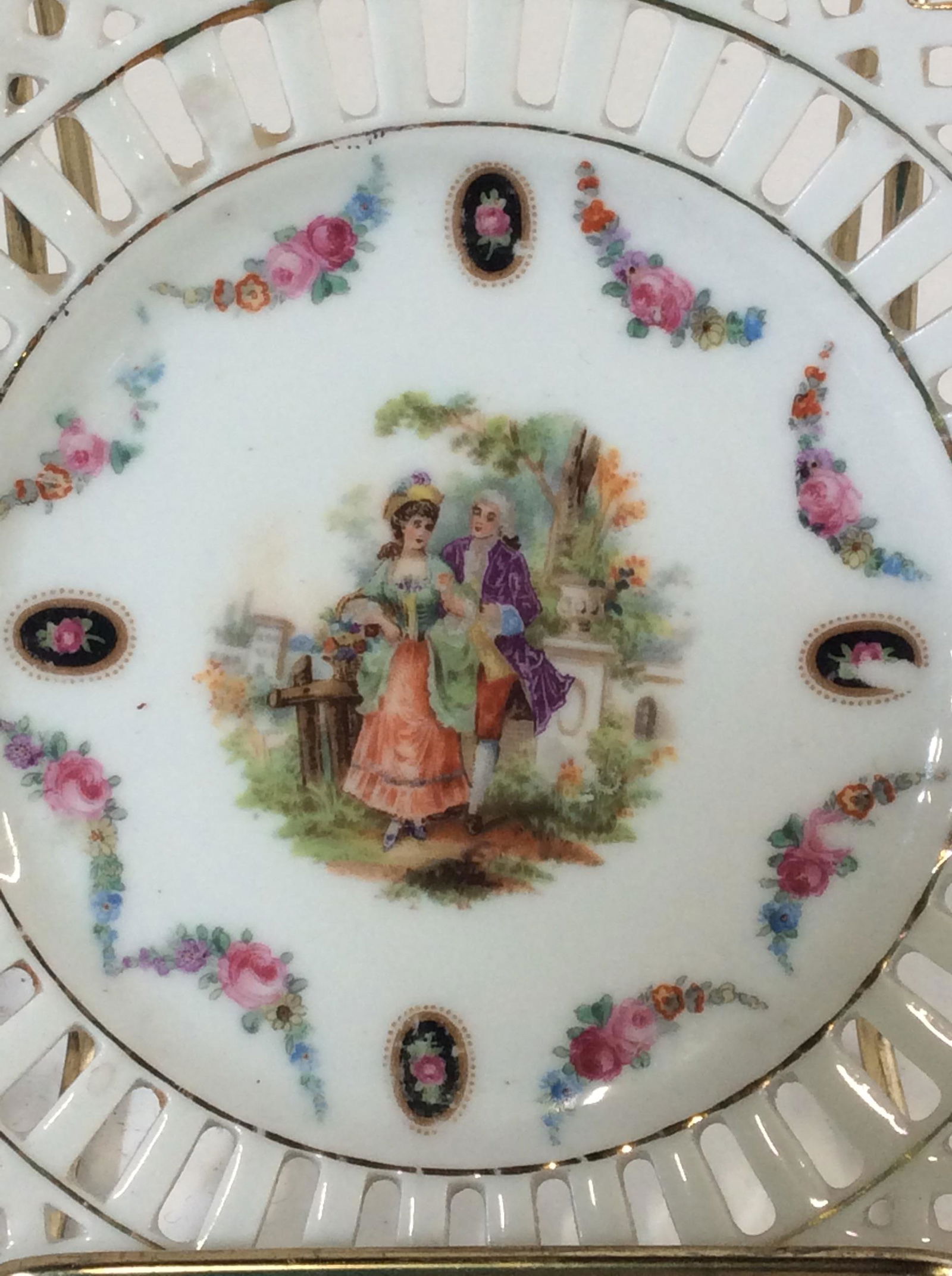 Set Hand Painted German Porcelain Plates: Lot 10. Set 8 Pierced porcelain dessert plates/ coasters, Tea Bag Plates, Saucers. Outlined with Gilt and Decorated with Viennese Courting Couple On Center Of Plate. 5 3/8 in diameter. Verso stamped G