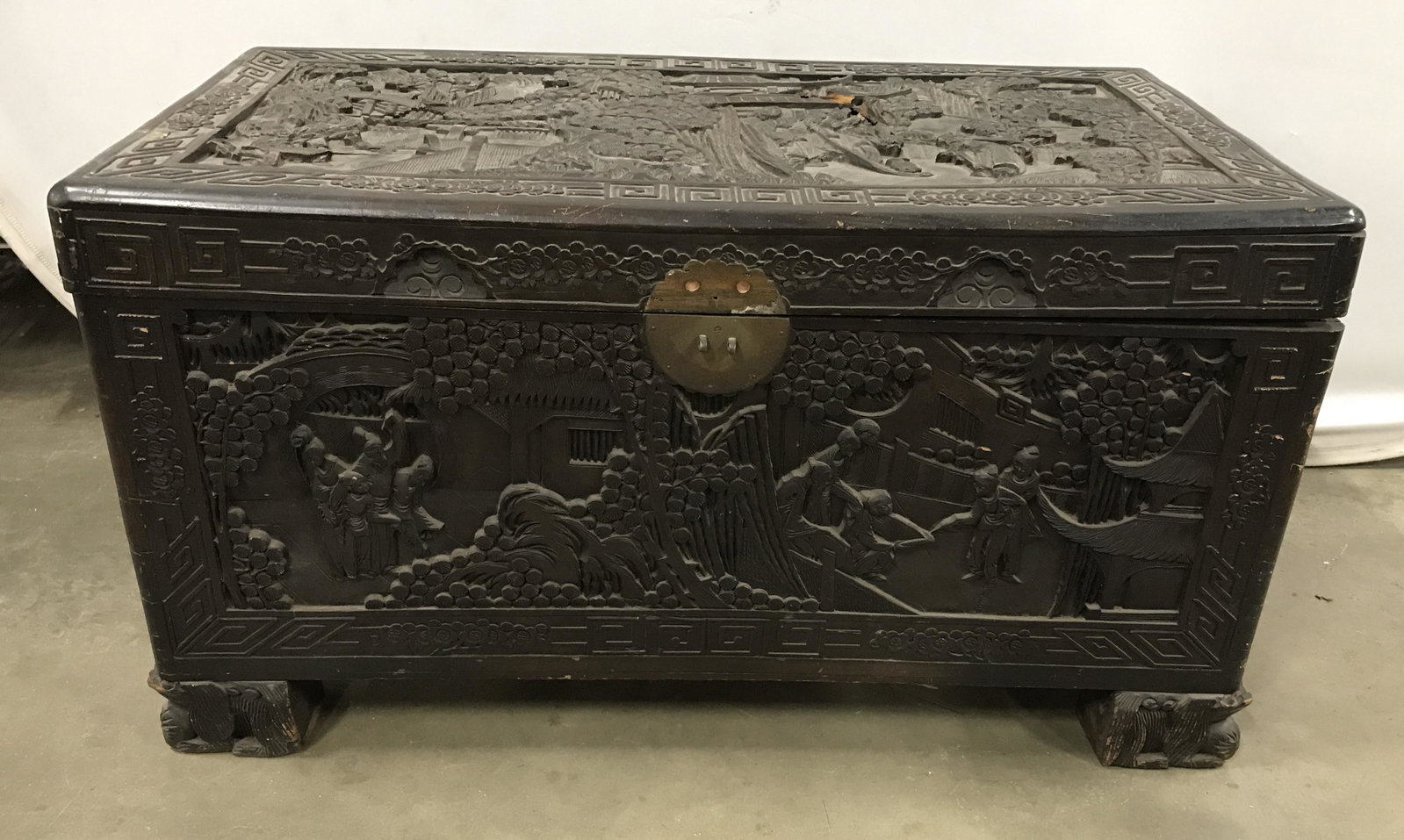Antique Ornately Carved Wooden Chest: Antique wooden chest. Ornately carved, asian style art. Depicts several groups of people performing various tasks in a garden. Measures approx 22 inches H, 40 inches W, and 21 inches deep. Wear is con
