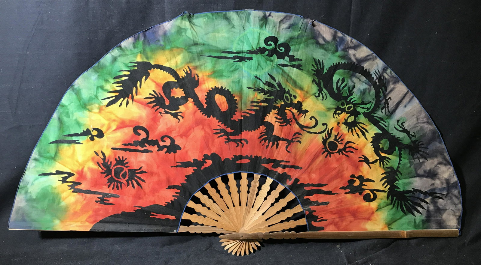 Vintage Oversized Handheld Fan: Vintage fan, crafted from wood and what appears to be silk. Fabric is tie dyed and depicts dragons among clouds. Measures approx 23.5 inches H, and 43 inches W. Wear is consistent with age and use. Pr