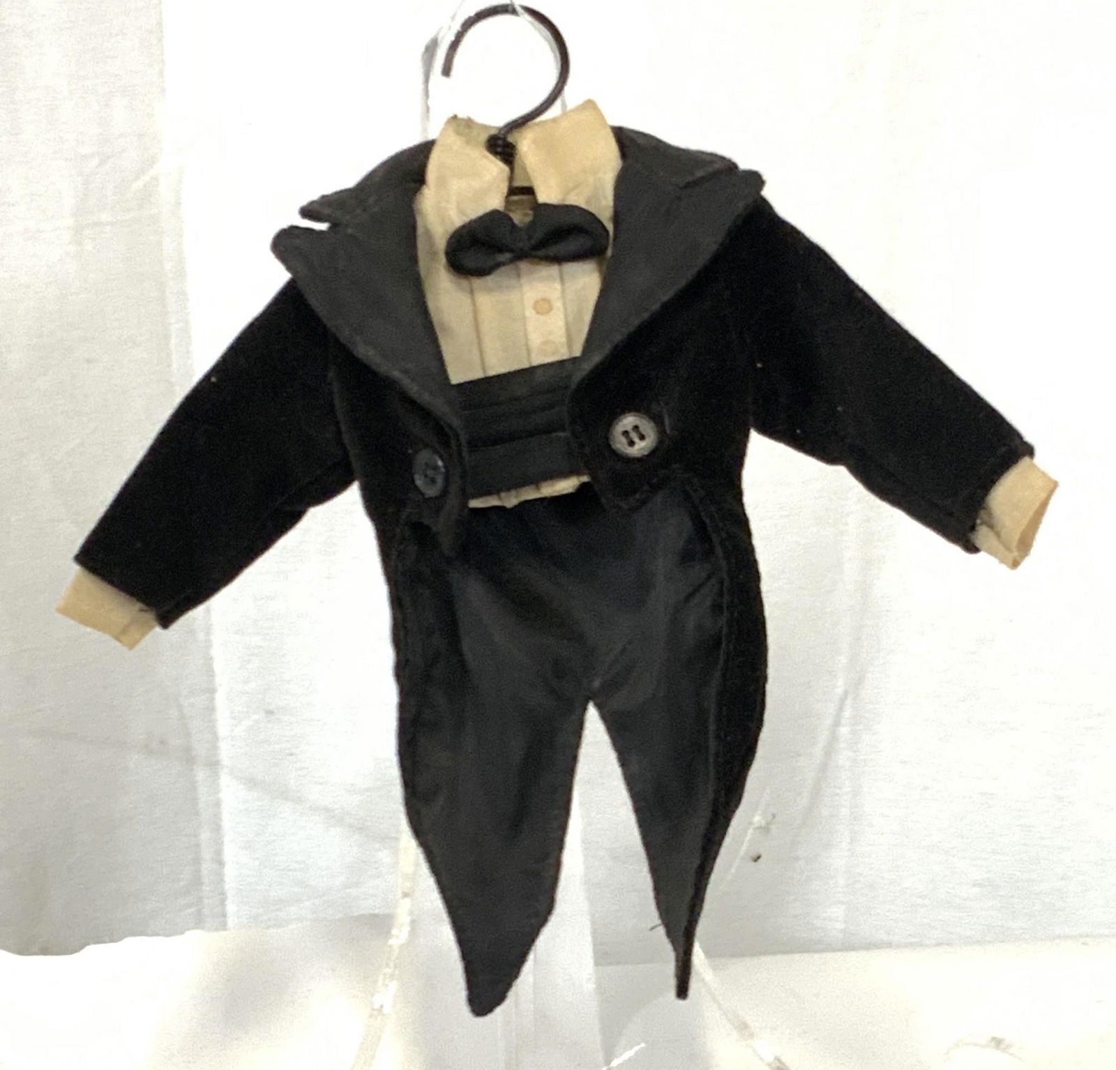 Collectible Vintage Doll's Suit Jacket: Black vintage suit jacket w/ attached undershirt & bow tie. Two black buttons adorn the jacket. Comes w/ small metal hanger. Approx. 10 in. width Approx. 8 in. height Vintage Collectible, collectible