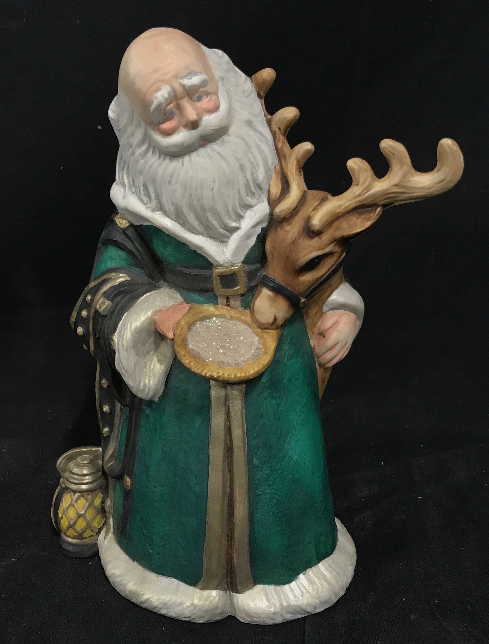 Ceramic Santa Figurine: Ceramic Santa Figurine, no apparent stamps or signatures, figurine depicts Santa in a green coat feeding a reindeer from a bowl, measures 11 inches at tallest point, hand painted, overall in good cond