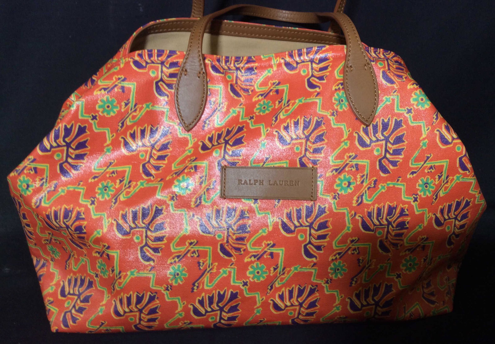 Luxe Ralph Lauren Orange Canvas Tote Bag: A Ralph Lauren polo gold tote bag, medium brown leather trim, East Asian Pattern, purple and green on orange canvas. Handle drop 7.5 in. 1 zippered interior pocket, tan fabric interior. Signed leather