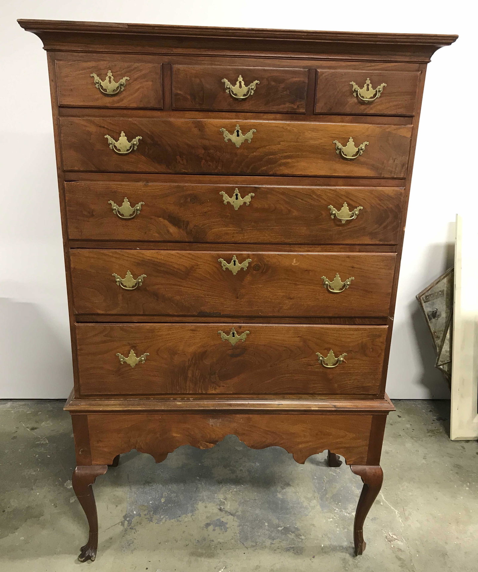 Antique Traditional Highboy Chest: Traditional highboy chest, piece is antique. 4 drawers with brass locks and drawer pulls, sits atop 4 cabriole style legs, feet are carved to resemble paws, front right foot is in need of repair. Draw