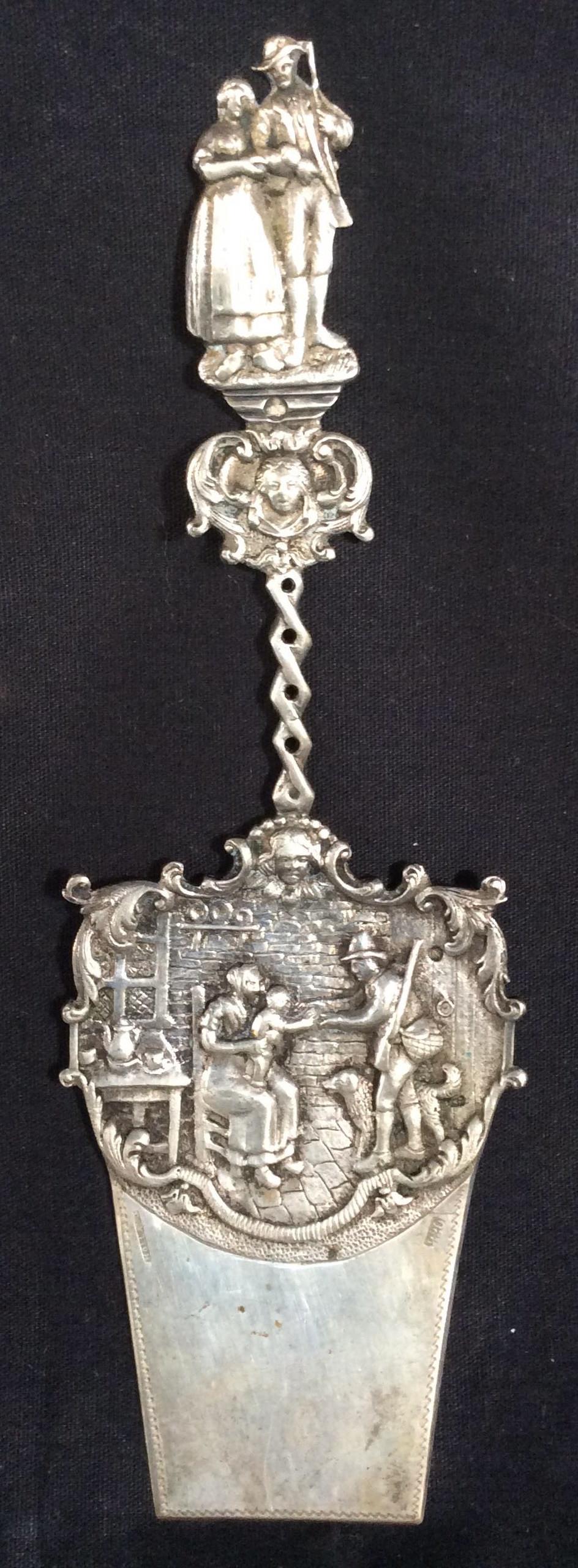 Antique .830 Silver Repoussé Cake Server, Holland: A European Antique Hallmarked . 830 near design. Depicts a Dutch family by a brick wall, father and dog greeting baby. A Pewter Tea Set behind the lady. Very detailed original Dutch craftsmanship, cre