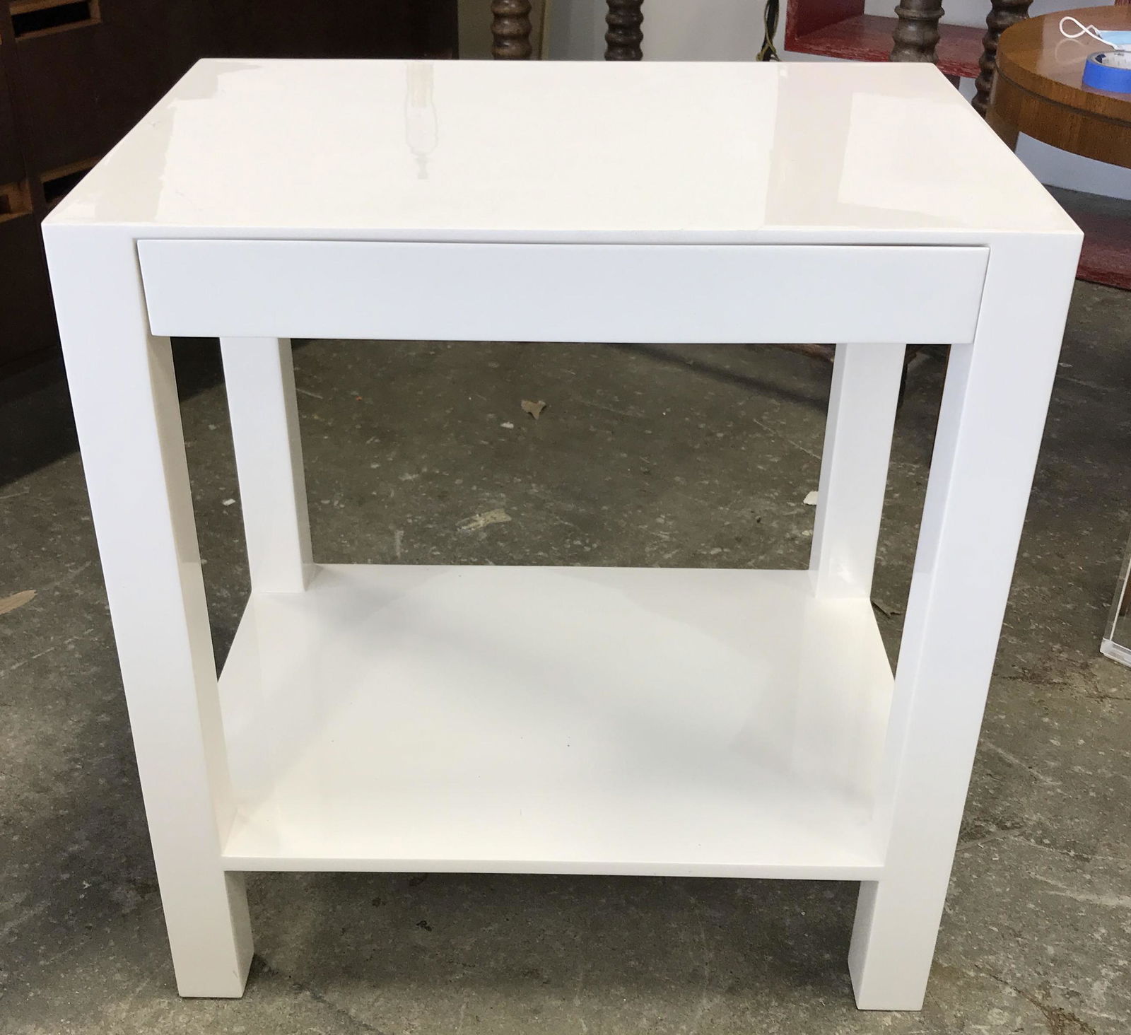 White Toned Console Table: White toned console table. Table is white toned, table houses a drawer. Lacquer finish. Drawer interior is lined with, what appears to be, cream toned leather. Each table measures approx 28 inches H,