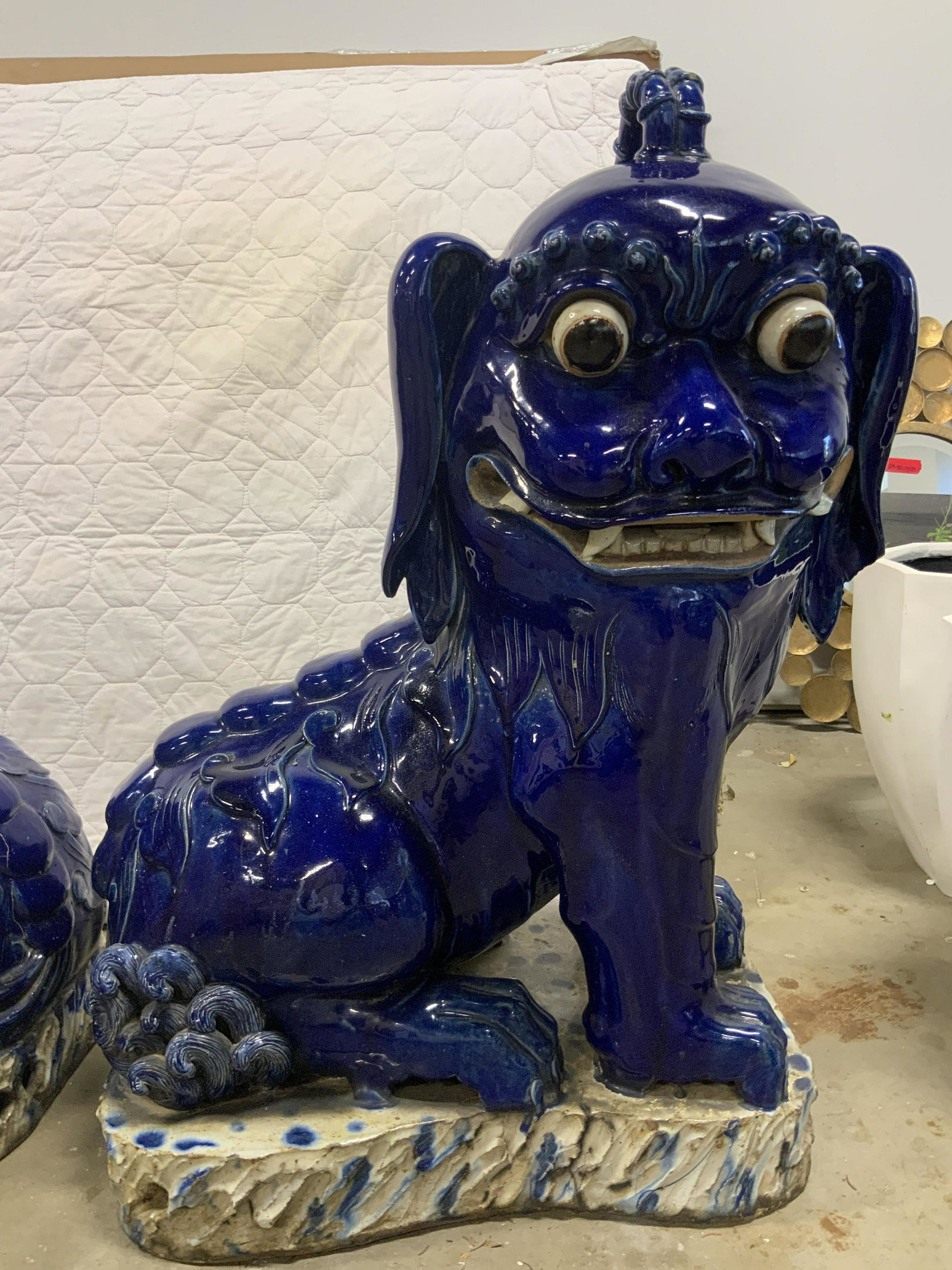 Pair Oversized Glazed Ceramic Foo Dogs: Pair of oversized foo dogs. Each is colored a deep navy blue, depicts foo dogs sitting on platforms. Each foo dog is hand painted and hand made. Each measures approx 44 inches H, and 23 inches W. Wear