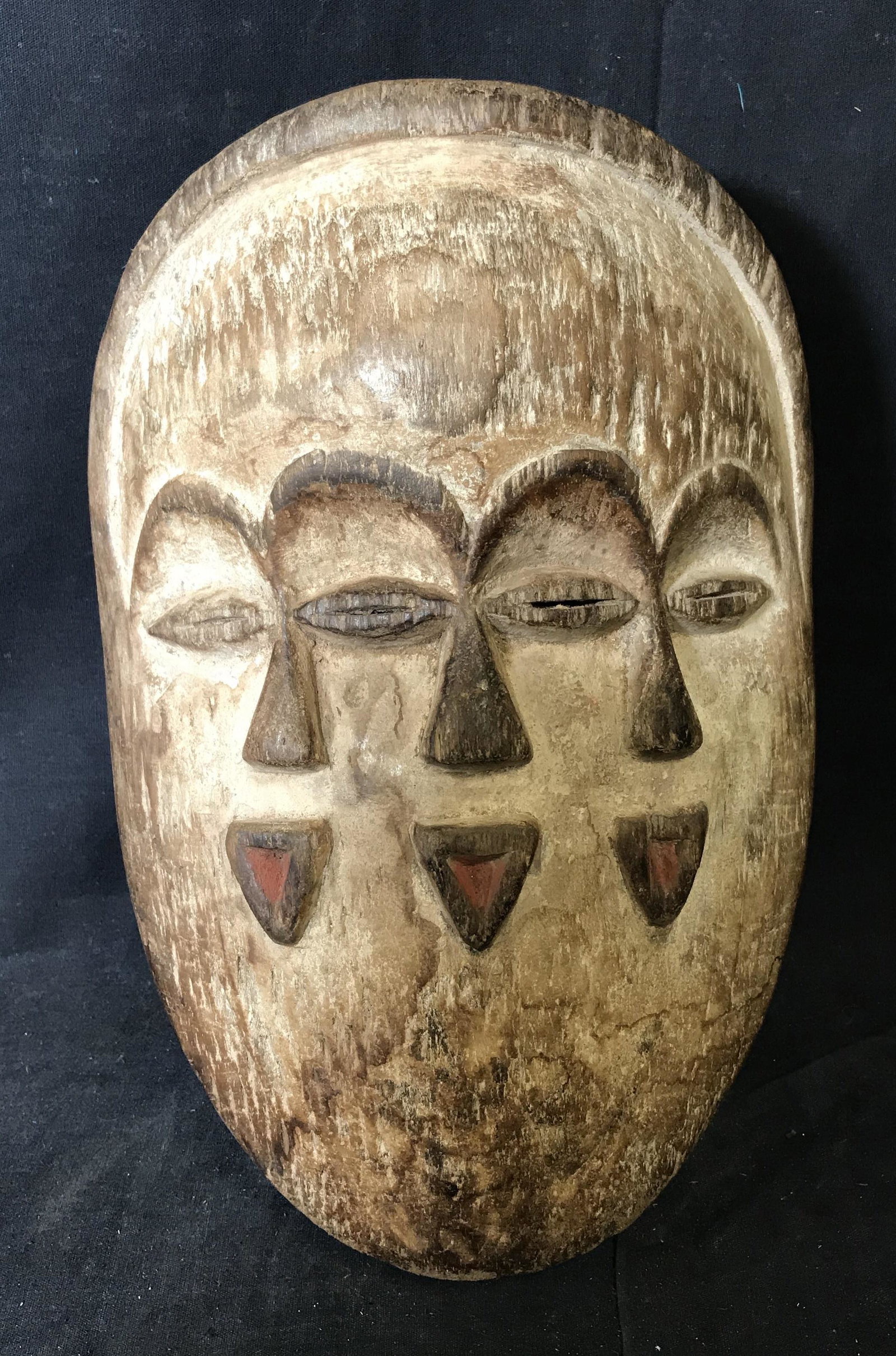 Gabon Mitsogo Multiple Faces Mask: Gabon Mitsogo Multiple Faces Mask, origins of the Mitsogo people can be found in Gabon Central Africa, painted with white brown and red pigment includes three faces that share two eyes, measures appro
