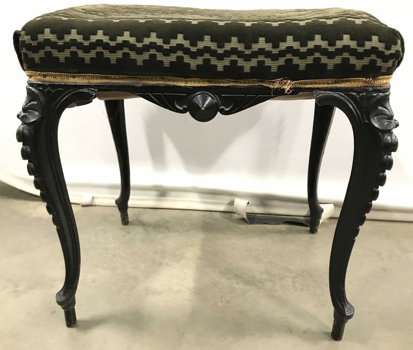 Vintage Upholstered Metal Leg Footstool: Footstool is upholstered with forest green toned upholstery which appears to possibly be crushed velvet. Piece has black toned metal legs. Measures approximately 21 inches tall and wide 15 inches deep