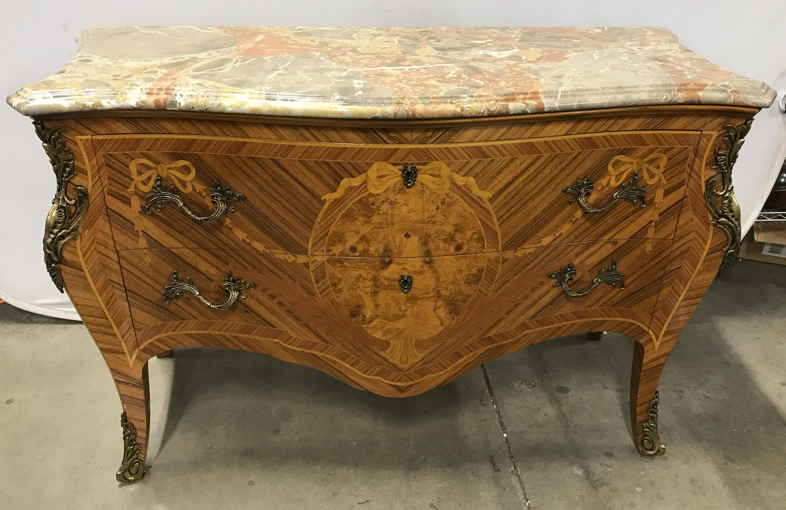 Vintage Marble Topped Wooden Dresser: MARBLE Topped Wooden Dresser, possible vintage. Brass drawer pulls, and locks are present, intricate brass detailing on front corners and legs. Veneered exterior, depicts bows draping lever drawer pul