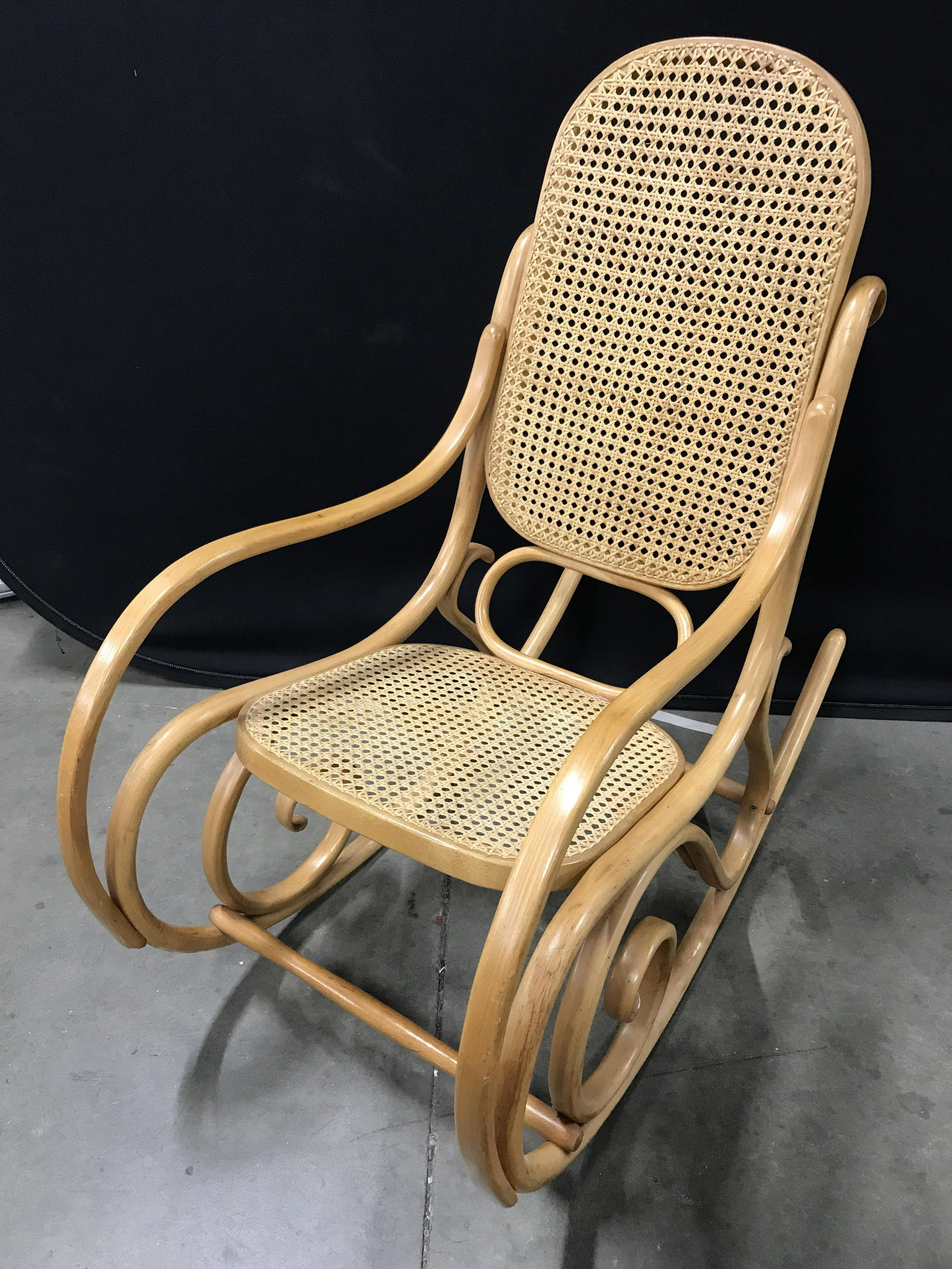Vintage Bent Wood Rocking Chair: Bent wood & cane rocking chair, possibly vintage, possibly antique. Wood frame is bent, allows for rocking, produces unique shape. Seat and back are woven cane. Measures approx 41 inches H, 20.25 inch