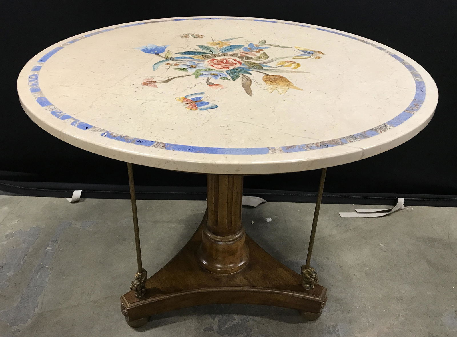 Vintage Marble Topped Pedestal Table: Vintage, possibly antique, pedestal table. Base is wood and brass. Three brass support beams, the base of each beam resembles a Griffin. Center column is fluted, table top is hand painted and depicts