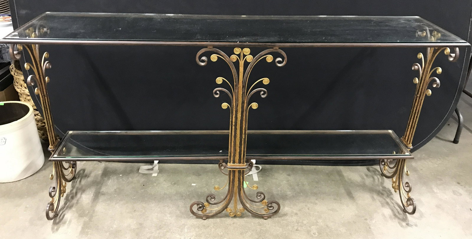 Vintage Glass & Metal Console Table: Vintage console table. Table is two tiered, each tier is glass. Frame is metal, scrolled metal detailing, several scrolled portions are gilded. Measures approx 33.5 inches H, 66 inches W, and 16 inche