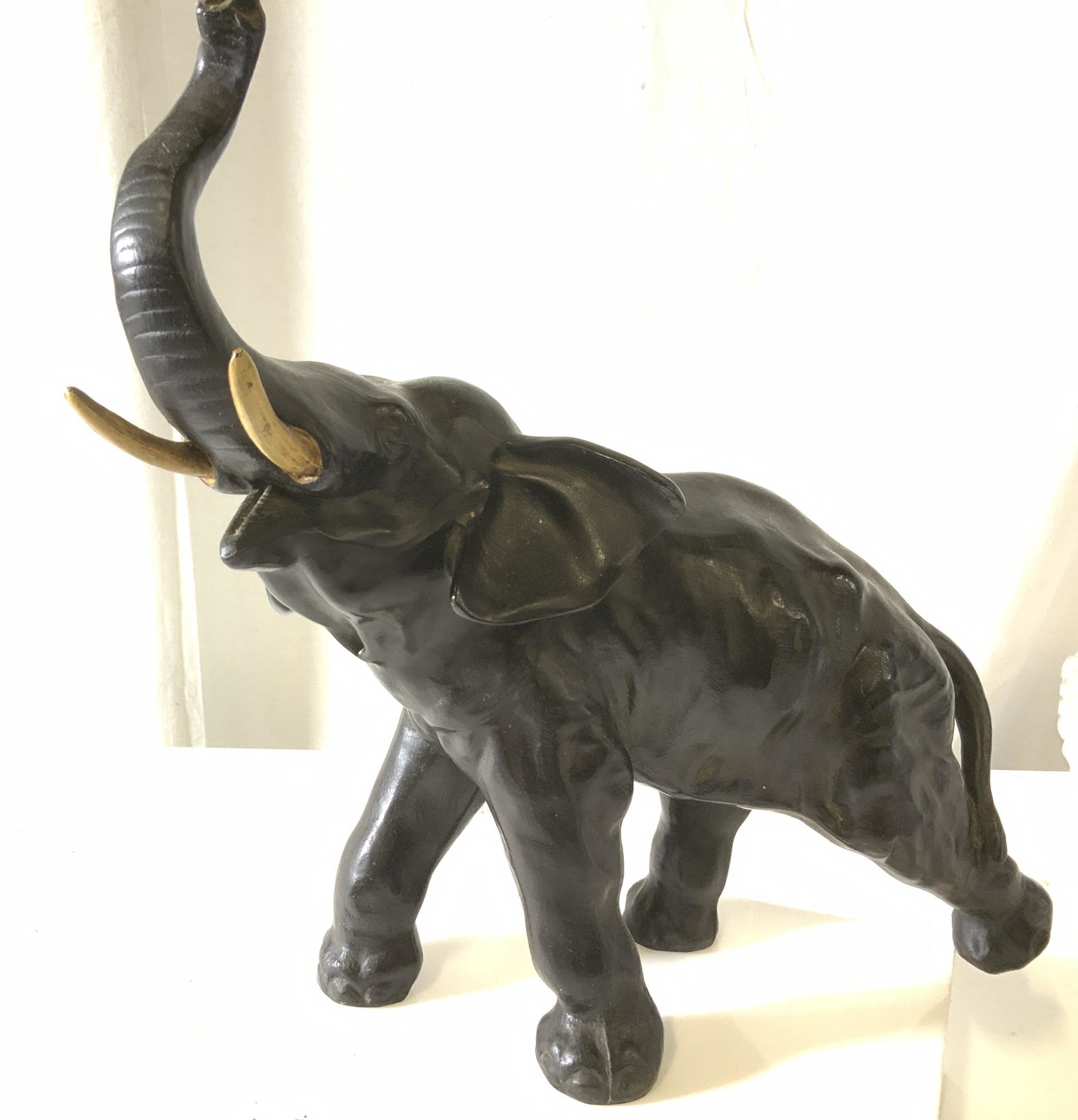 Cast Bronze Elephant Sculpture: Elephant in motion with her trunk up, head raised and mouth wide open. Painted metal tusks. Ht 14 in. Length app 16 in. Width app 8 in. Jungle Animal, Elephant Sculpture, Bronzed Elephant, Statement S