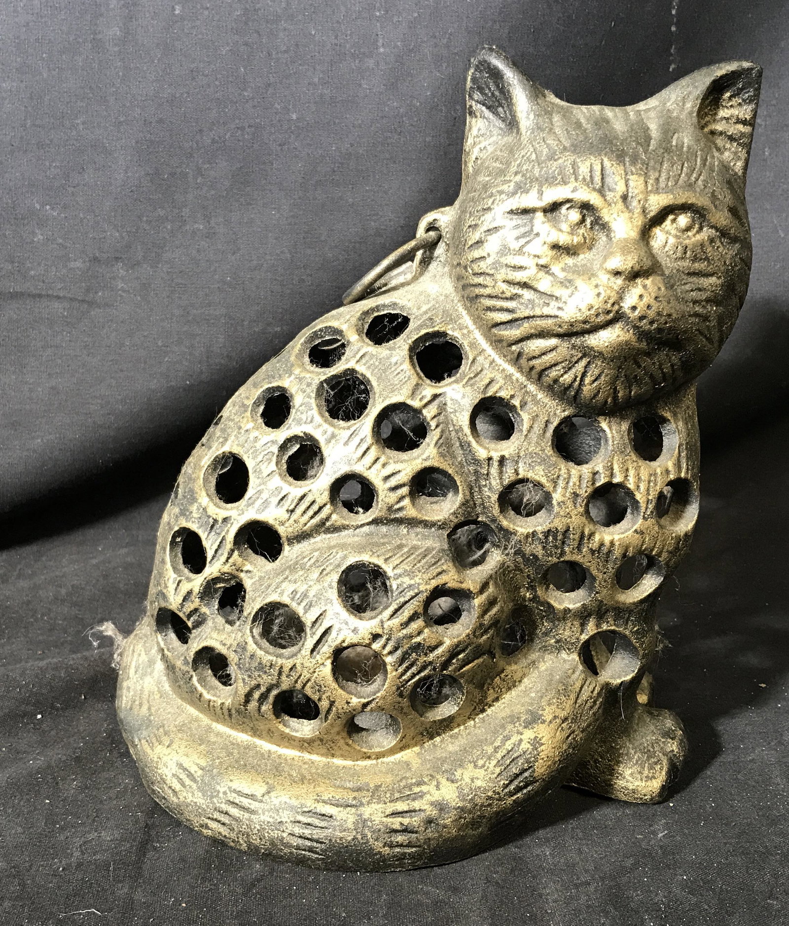 Bronze Cat Tea Light Holder: Bronze cat tea light holder, piece is hollow with holes to allow for light to shine through, plate on the inside has a small spike to allow for tea light attachment, piece has a ring attached to the b
