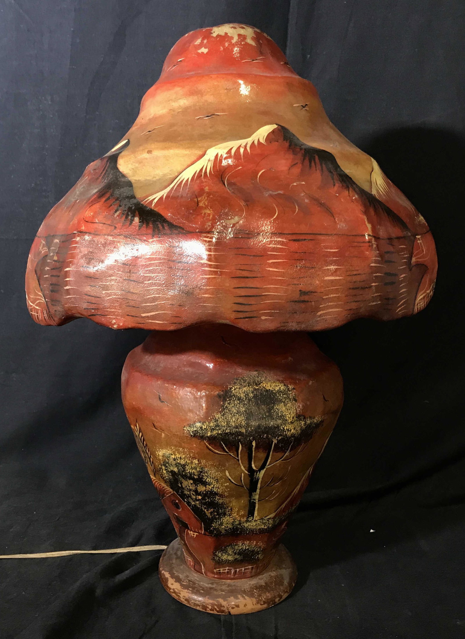 Hand Painted Pakistani Lamp: Hand painted Pakistani paper mache lamp, lamp painted in earthy clay colors, design to lamp depicts a landscape of sorts with mountain portrayed on the lamp shade, both body of lamp and shade are made