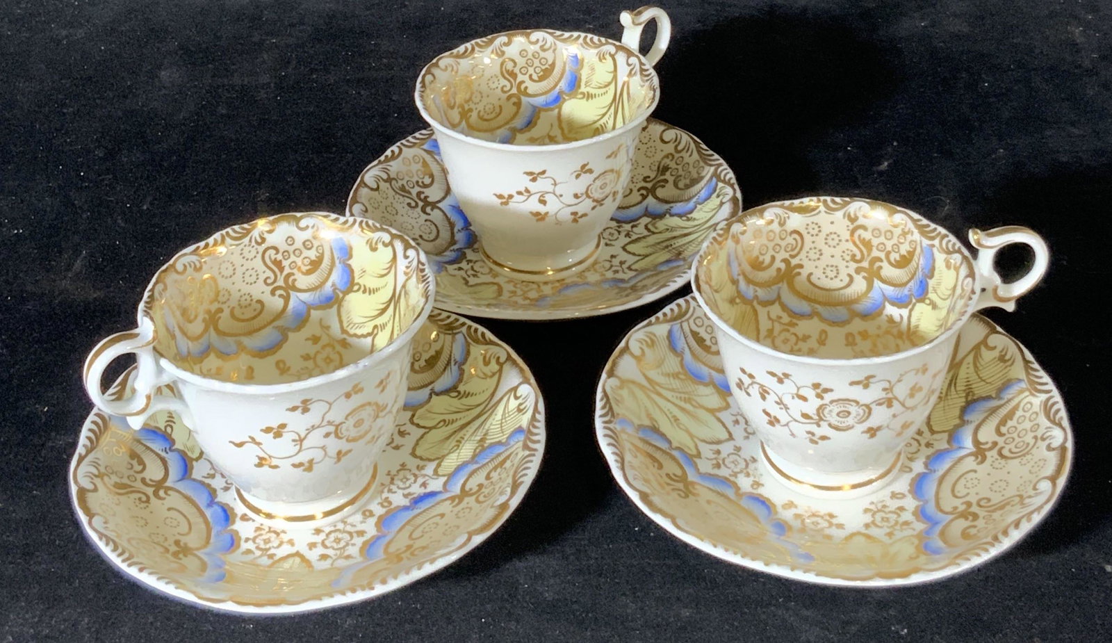 Lot 6 G. GRAINGER Porcelain Teacups & Saucers: Signed G. GRAINGER hand painted porcelain saucers and teacups. White porcelain w/ floral gilt designs & line work. Blue flower petal design. Some Undersides stamped, read: 1897 x, G. GRAINGER Royal Po
