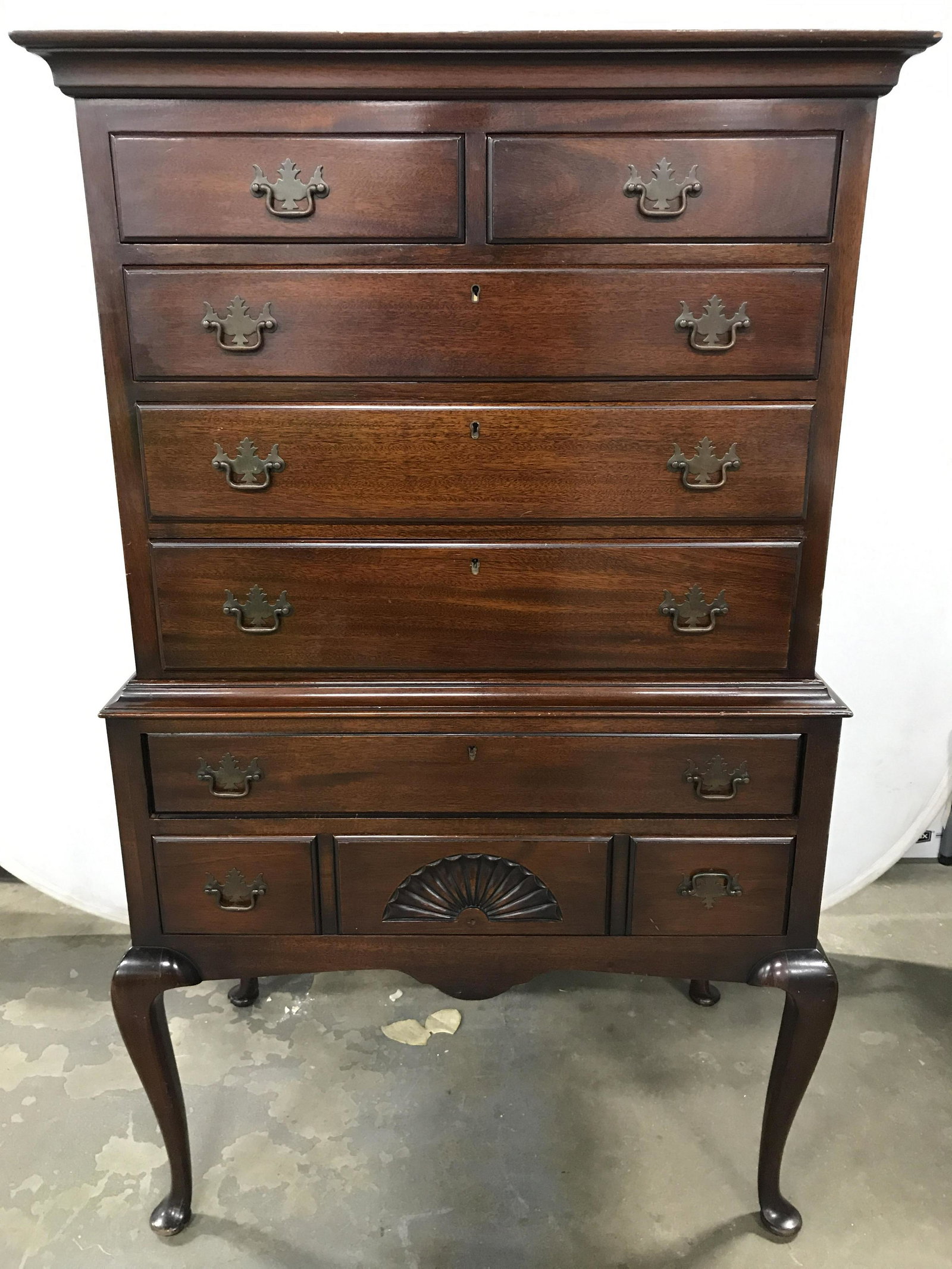 Vintage Mahogany Highboy Chest On Stand: Highboy chest is vintage. Piece appears to be mahogany. Chest has 7 total drawers. (2 small and 5 large.) Drawers have copper toned metal handles. Each drawer has hand dovetailing. Piece has cabriolet