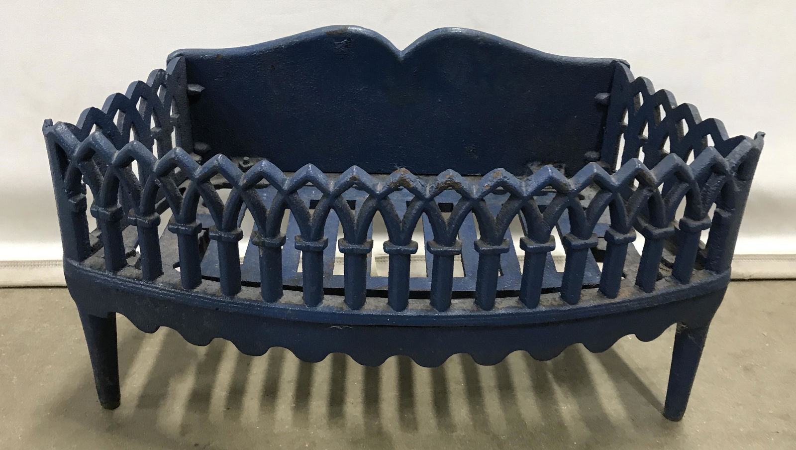 Antique Cast Iron Fire Grate: Cast iron fire grate. Colored in blue tones. Measures approx 10 inches H, 19 inches W, and 9 inches deep. Wear is consistent t with age and use. Fire grate, fireplace accessories, fireplace decor, vin