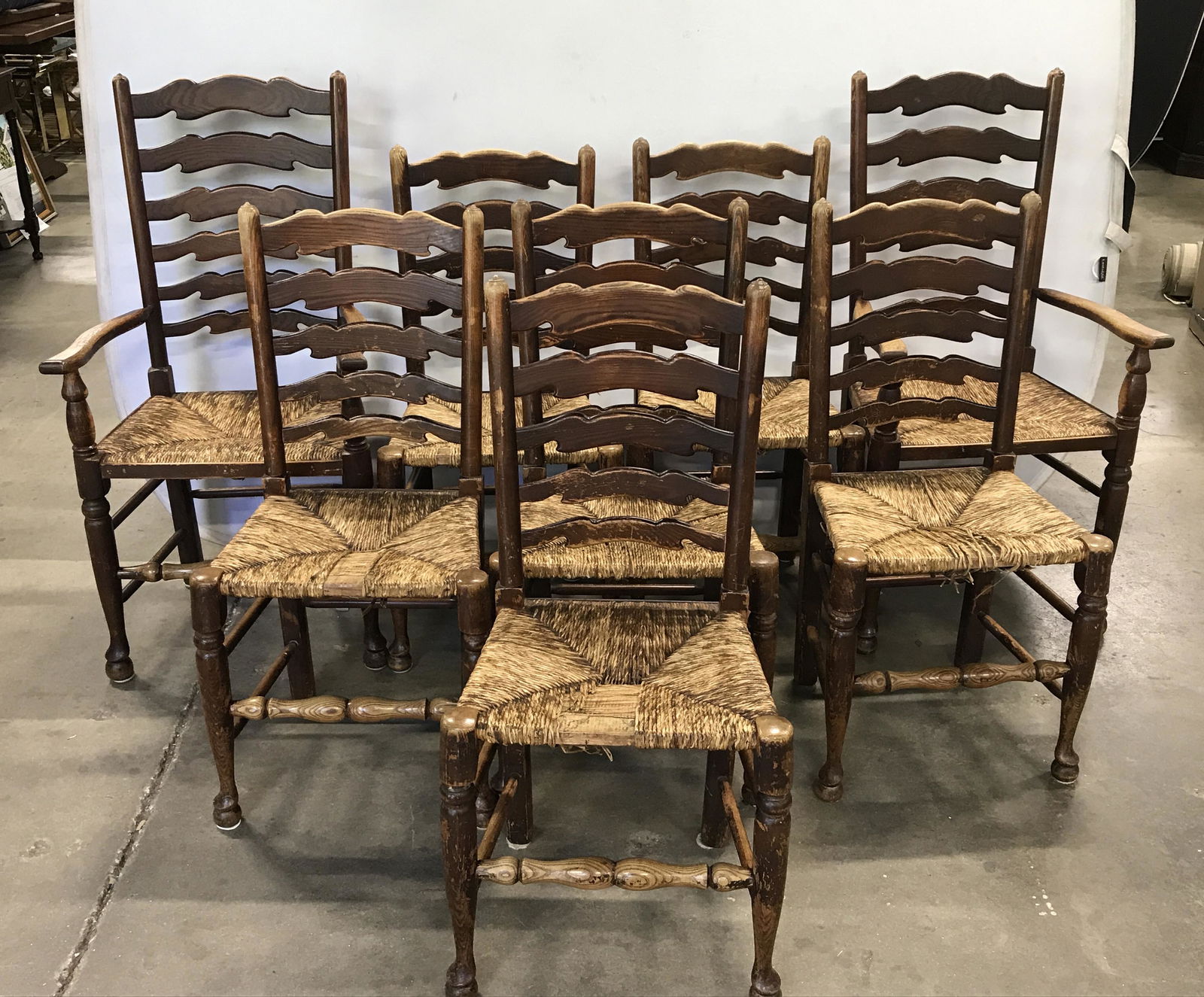 Set 8 Wooden Vintage Chairs: Set of 8 vintage, possibly antique, dining room chairs. Chairs are crafted from carved wood. Seats are crafted from rush, chairs are ladder backed, front stretcher is turned. Largest chairs measure ap