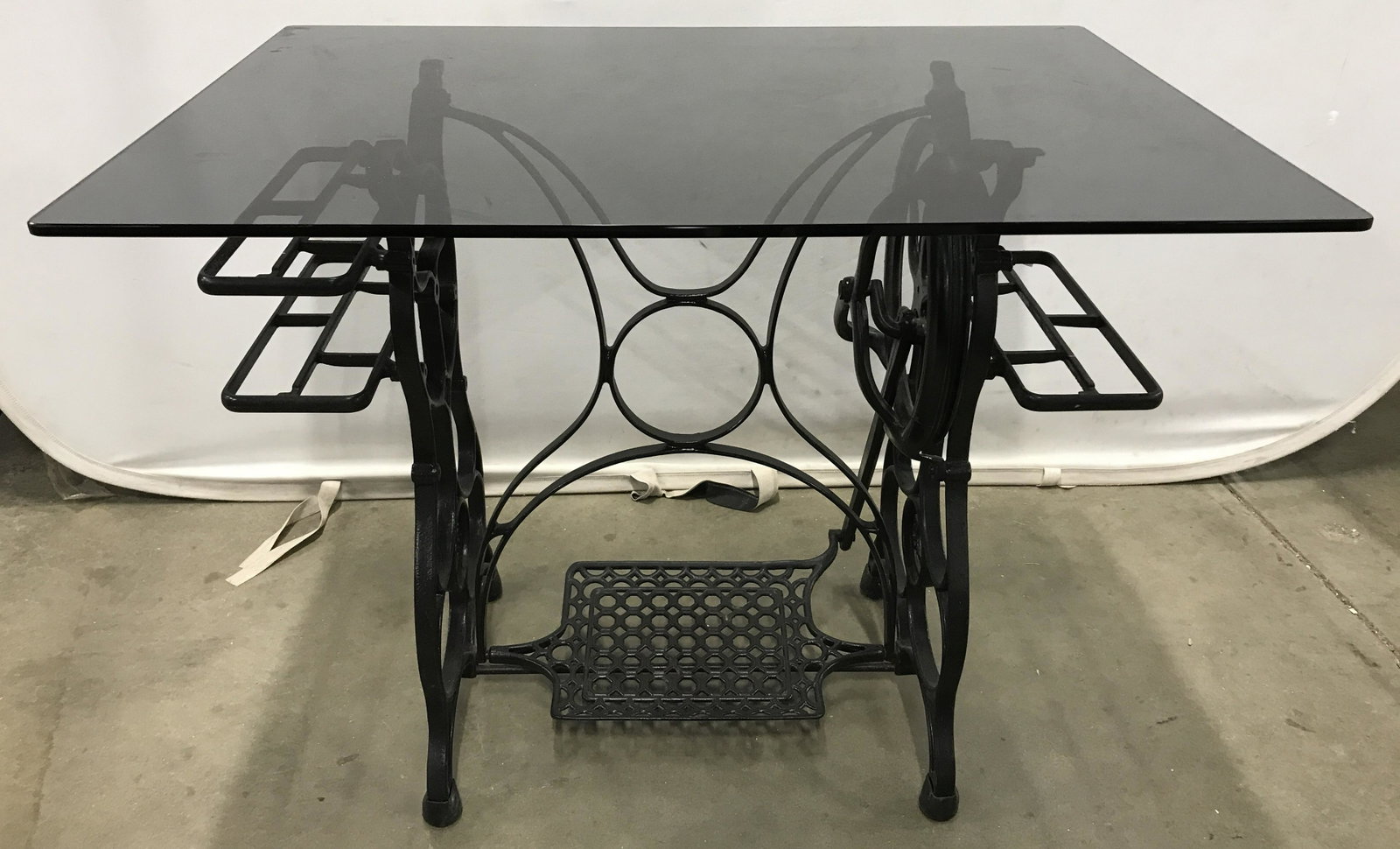 Glass Topped Converted Sewing Table: Glass topped table, converted from a sewing table. Possibly vintage. Sewing machine table frame is crafted from cast iron, sides read as STANDARD. Measures approx 28.5 inches H, 36 inches W, and 25 in