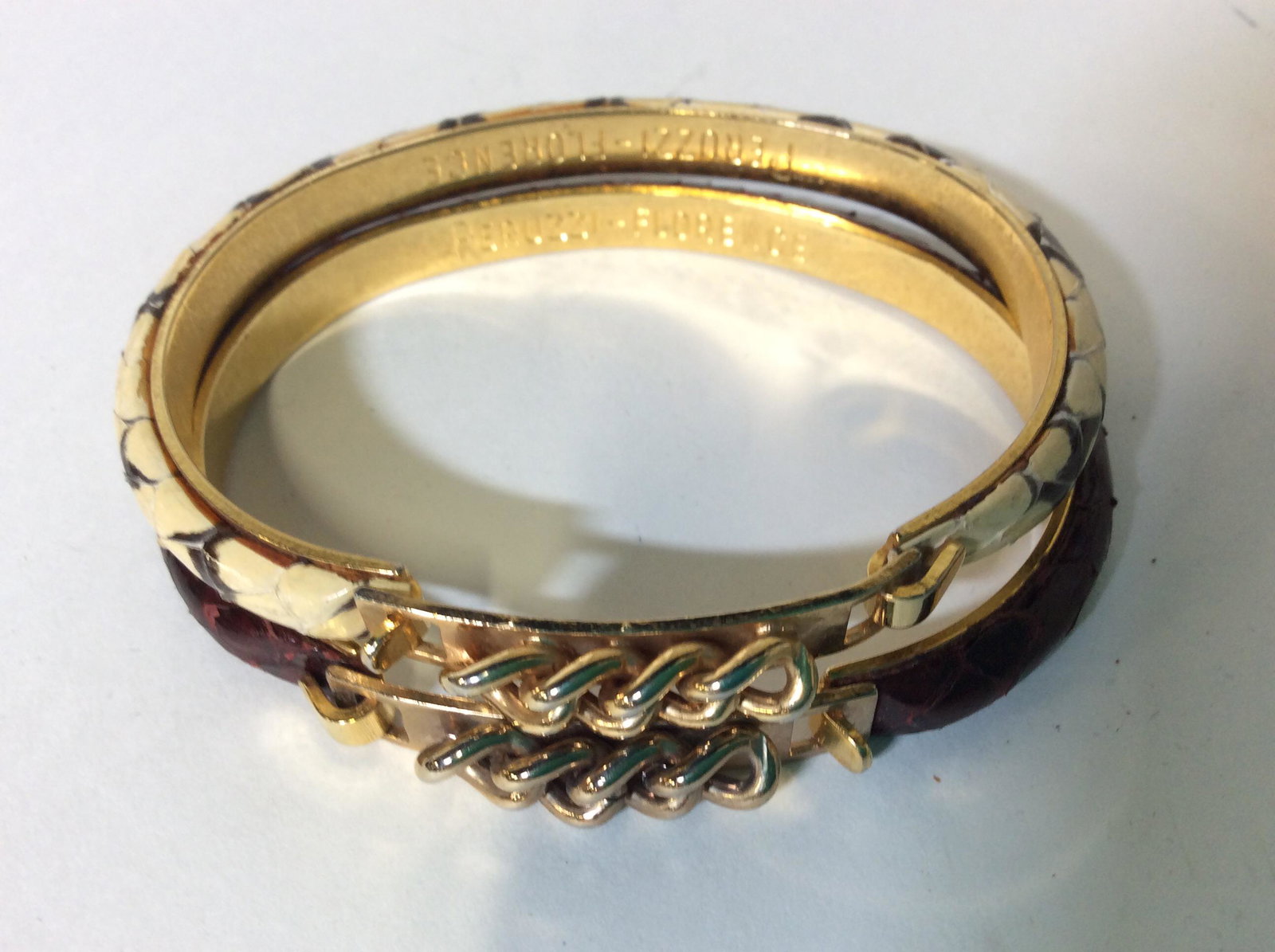 PAIR PERUZZI FLORENCE SNAKESKIN BANGLES: Signed Designer Bangles, Classic PERUZZI Snakeskin, one brown, one off white with dark accents, set on gold toned metal . Decorative Hook clasp with chain accent. 2.5 in. Snakeskin Bracelets, Snakeski