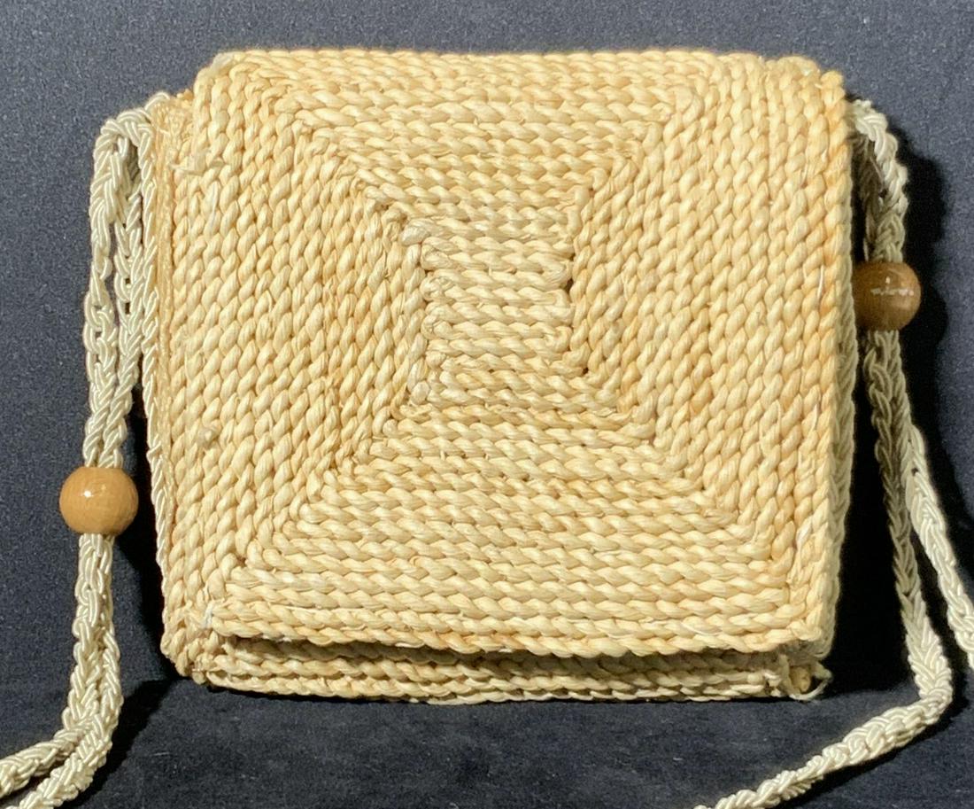 Square Woven Straw Crossbody Bag, Italy: Crossbody bag made from natural material (straw). Interior lined w/ beige textile. Snap button closure. Tag reads: Made in Italy. Decorative brown beads on braided fabric straps. Bag approx. 7 x 7 in.