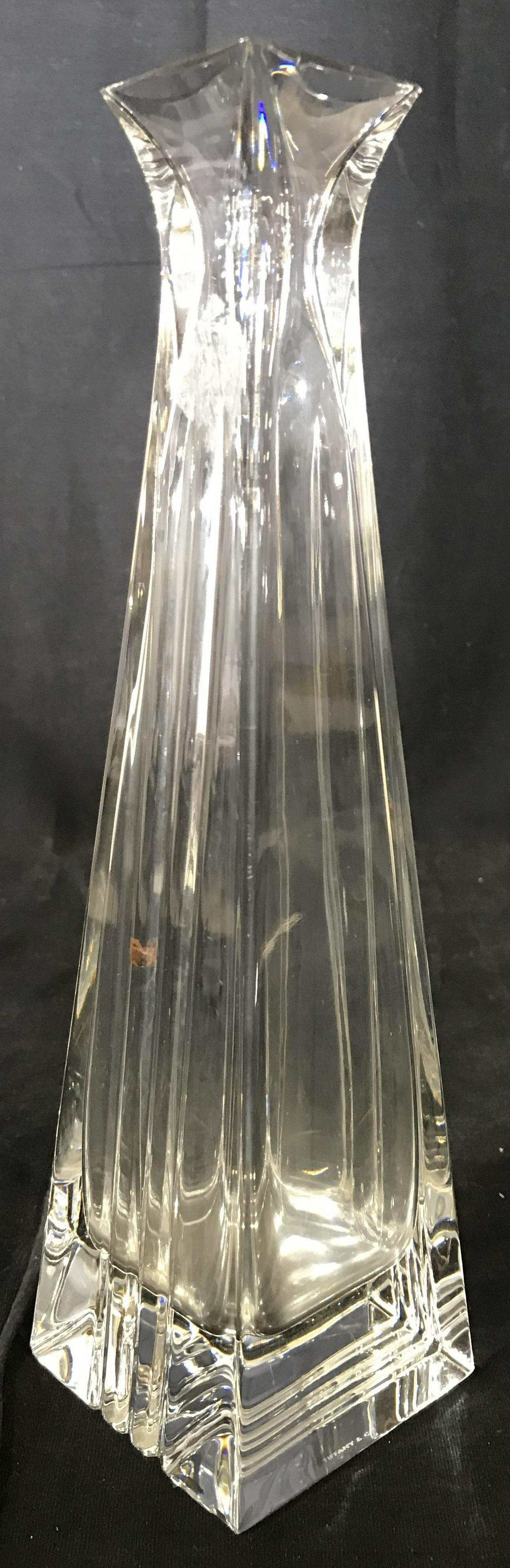 TIFFANY & CO Slim Crystal Vase: Underside of vase is marked TIFFANY & CO. Piece appears to be cut crystal. Vase has square shape at base and mouth. Piece has slim structure. Measures approximately 10 inches tall 2.5 inches wide and 