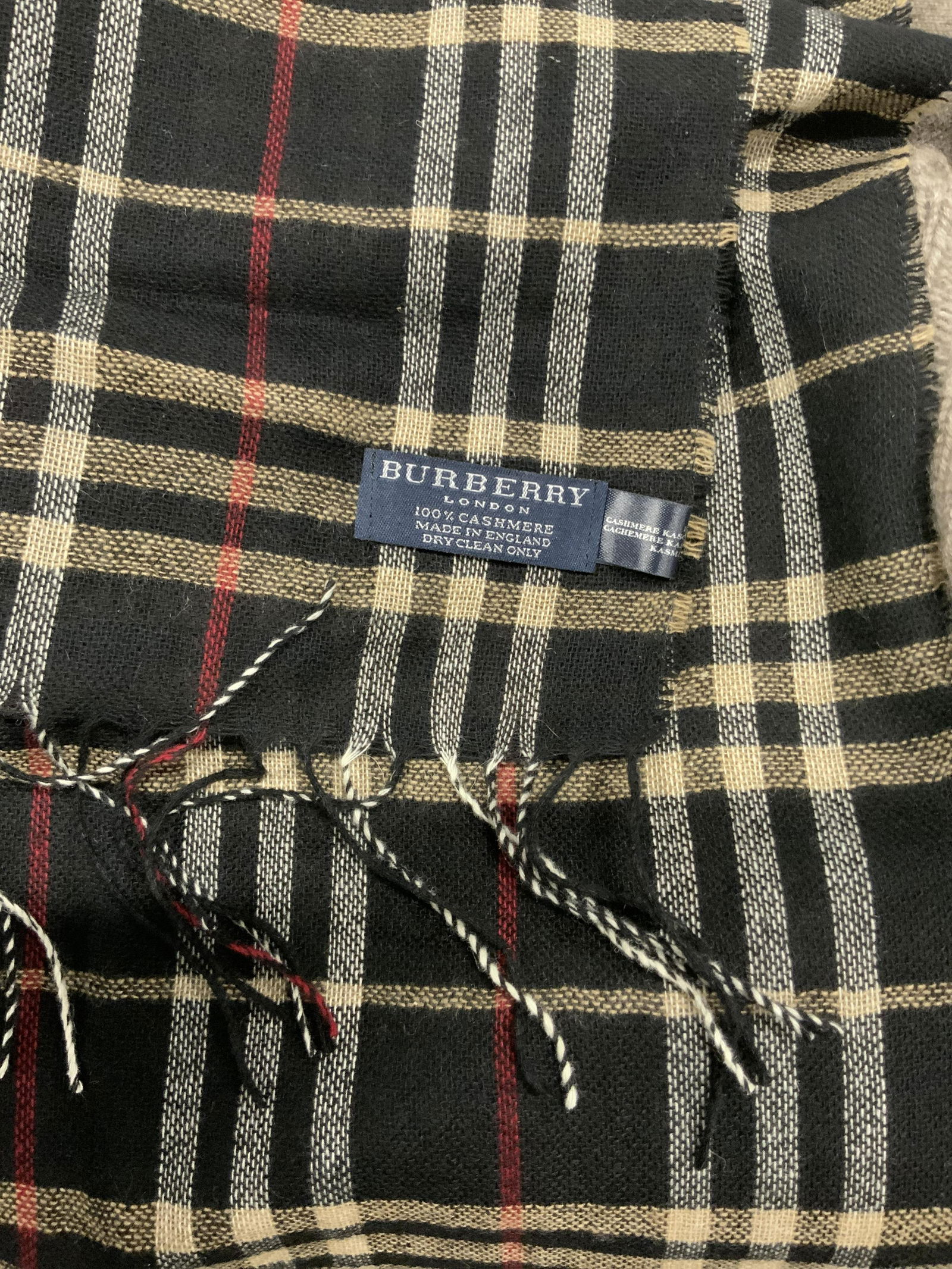 Burberry Black Nova Check Cashmere Wrap, London: Labeled scarf, shawl, wrap, thin woven cashmere, label reads BURBERRY LONDON 100% cashmere made in England dry clean . Semi transparent fabric. Black nova check. End tassels. 32 in x 84 in. Burberry o