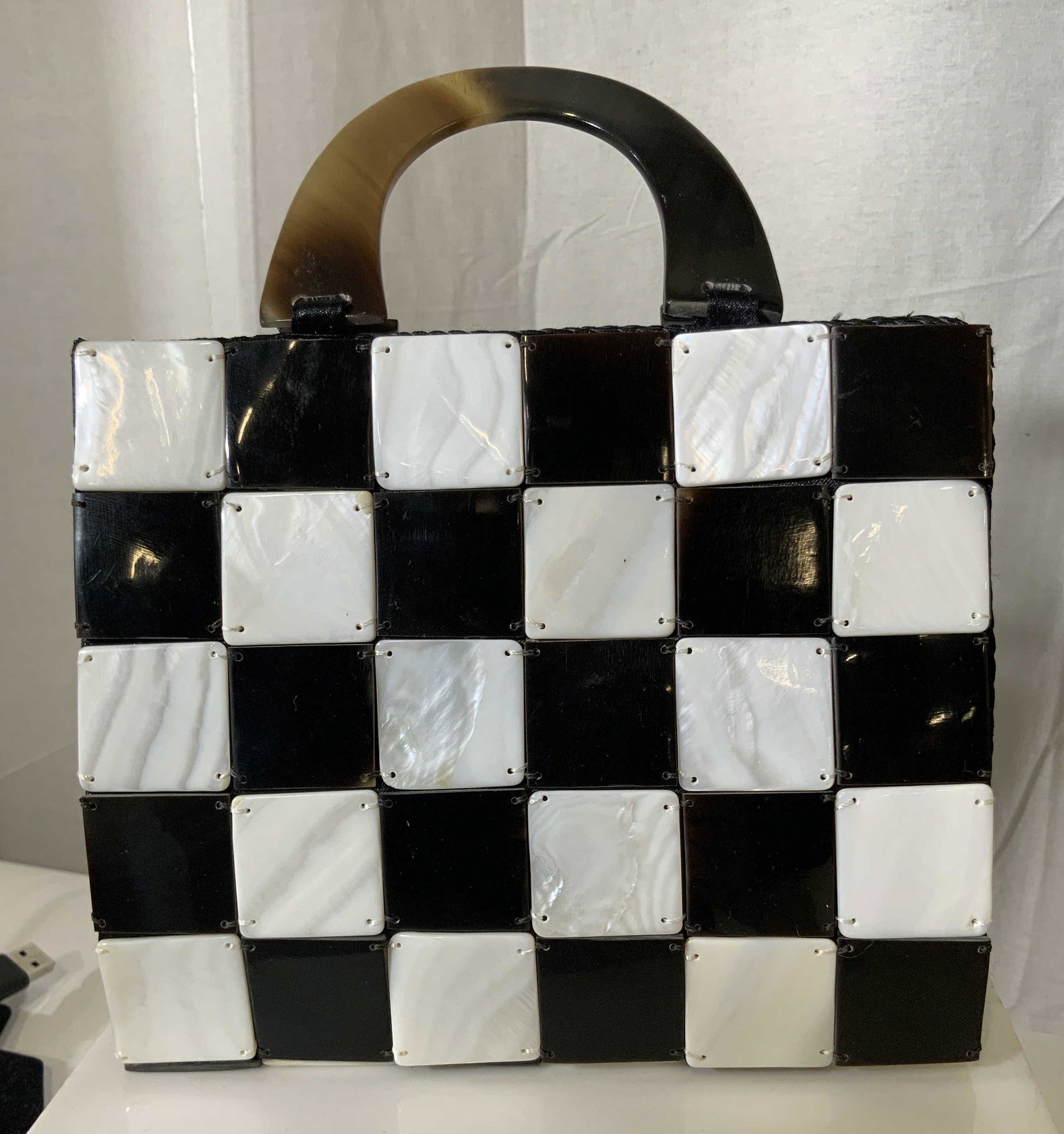 Black & White Checkered Handbag W Bakelite Handle: Black & White Checkered Handbag W Bakelite Handle Fabric bag with flat square Checkered discs hand sewn on both sides. Bake light style handle, drop 3 in., 1 in wide. Purse ht 6 in. Width 7.25 in. Dep