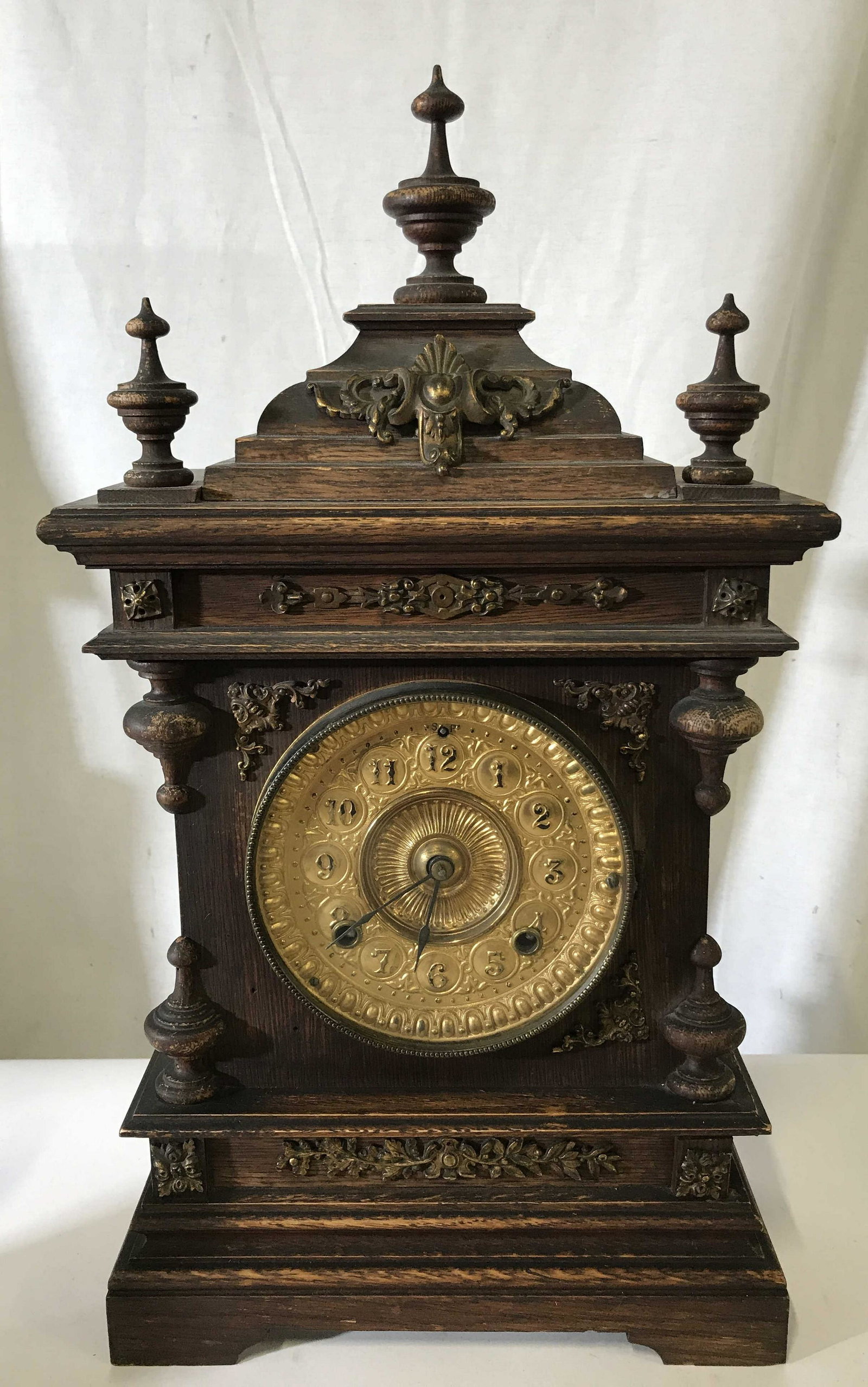Dark Carved Wood Gilded Metal Mantle Clock: Dark Carved Wood Gilded Metal Mantle Clock Dark Wood Mantle clock, Made of a dark stained wood, added gold toned metal accents with tarnish to them, carvings and metal detailing done in a baroque styl