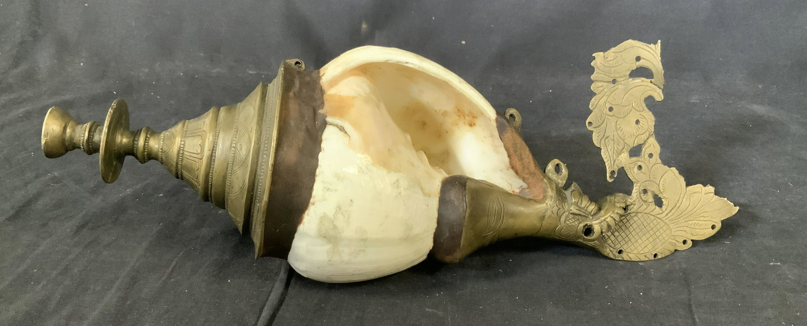 Conch Shell and Metal Sculptural Trumpet: Conch shell trumpet, no apparent inscriptions or stamps, Intricate incised design, possibly bronze, measures 14 1/2 inches long x 5 inches at widest point, Heavyweight object, tarnishing to metal but 