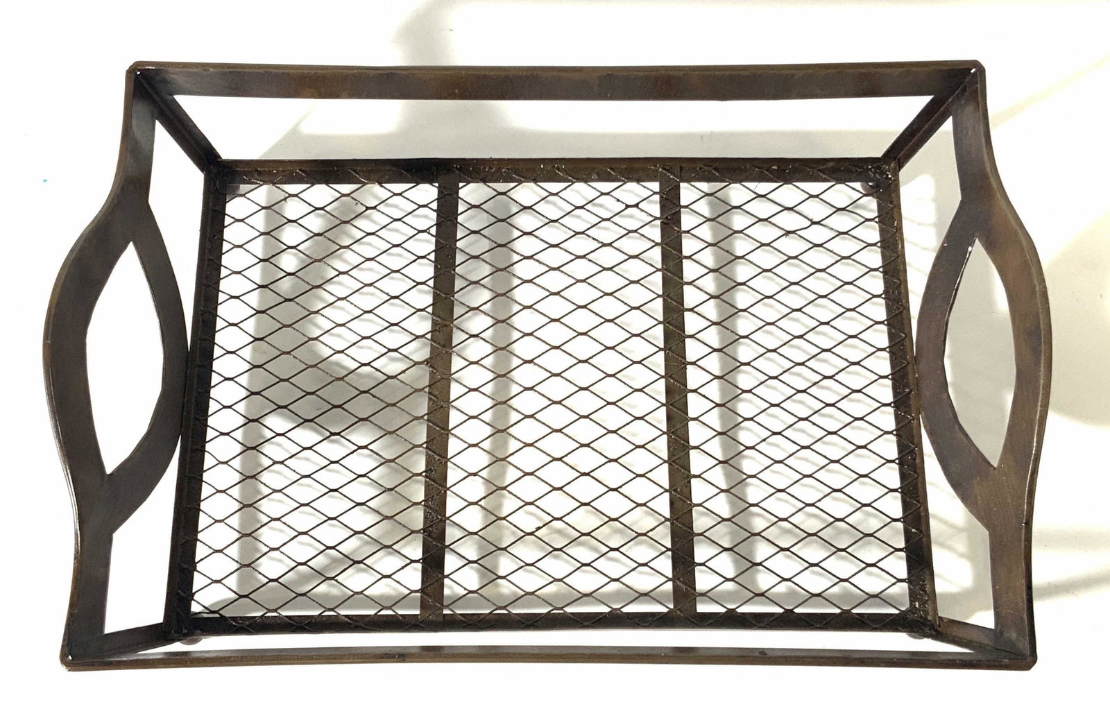 Decorative Brown Metal Wire Basket: Brown metal wire basket. Open sides, underside wire. Underside possesses circular feet. Some residue. Approx. 15 in. length. Approx. 3 in. height. Brown basket, wire basket, document storage, paper st