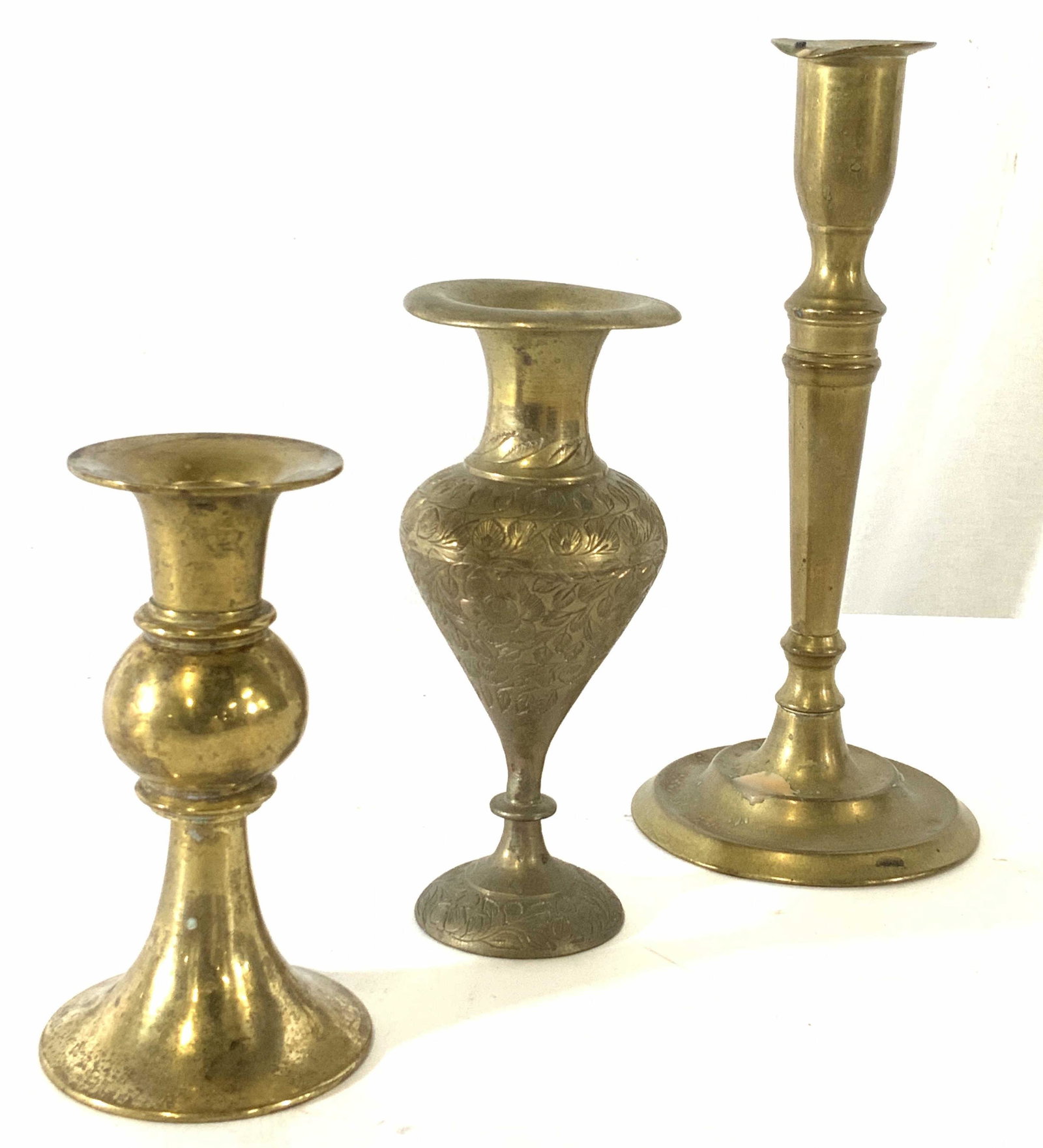Lot 3 Vintage Brass Candlesticks, Brassware: Shortest is candlestick with reverse trumped base, smooth polish brass, 5 in ht. Middle is vase with middle eastern style, reticulated etchings of florals with high waisted bottle pedestal. Tallest is