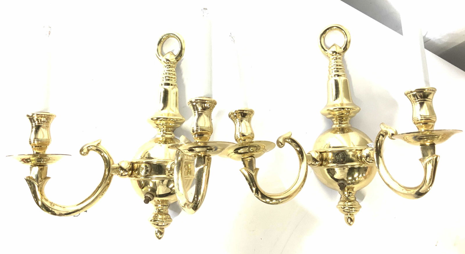Pair Brass Wall Sconces: Pair wall sconces, all brass, each with 2 chandelier lights. Turn switch. Upper circle to hang on wall , center 13 in ht. Lights rise app.5 in higher than center fixture. 12.25 in wide. 7.25 in depth.