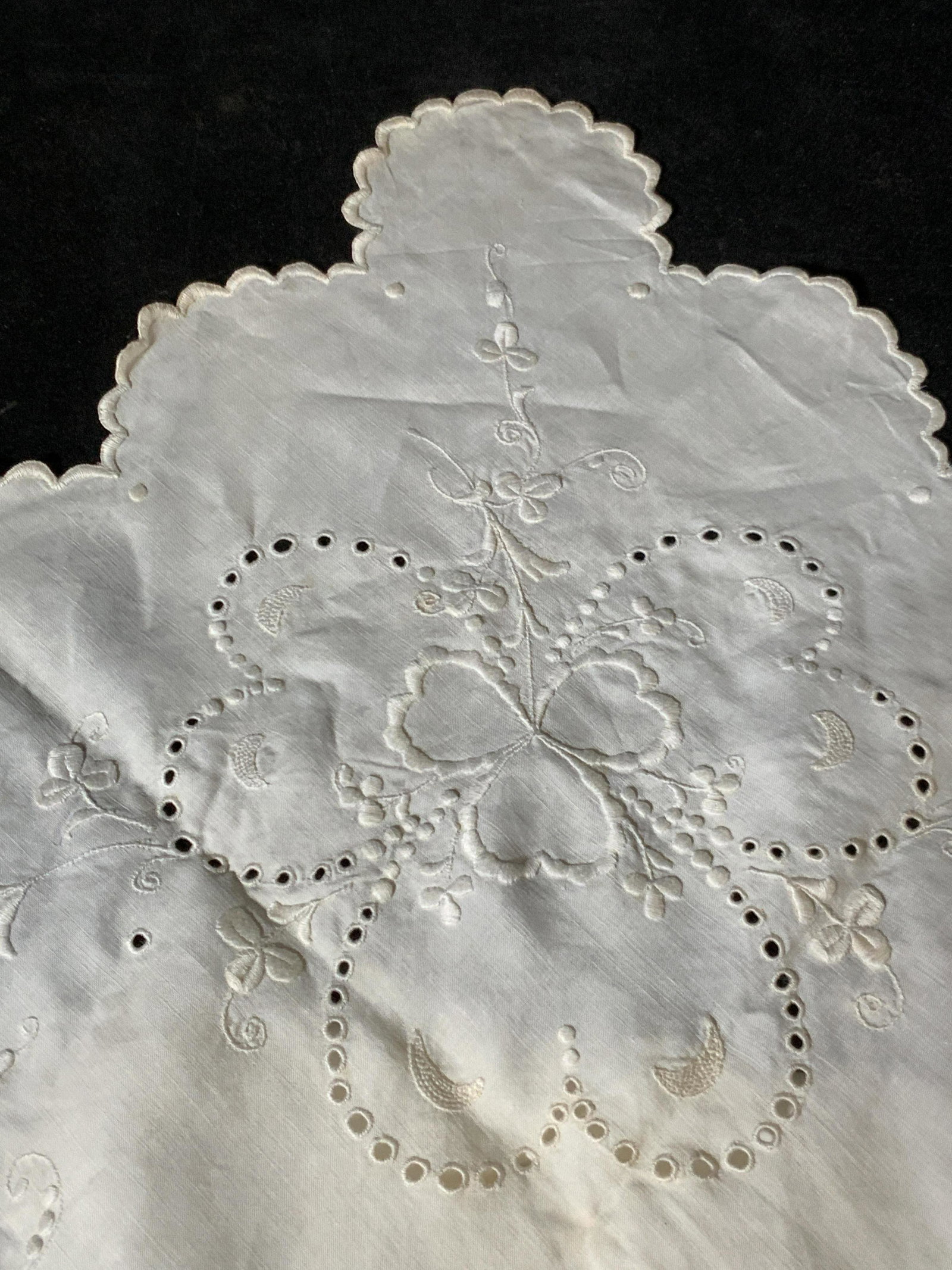Vintage Embroidered Tablecloth: Small white vintage tablecloth with pieced fabric, embroidery, and scalloped edge details. Clover designs throughout piece. Vintage condition, some staining and yellowing. Approx. 41 x 41 in. Vintage 