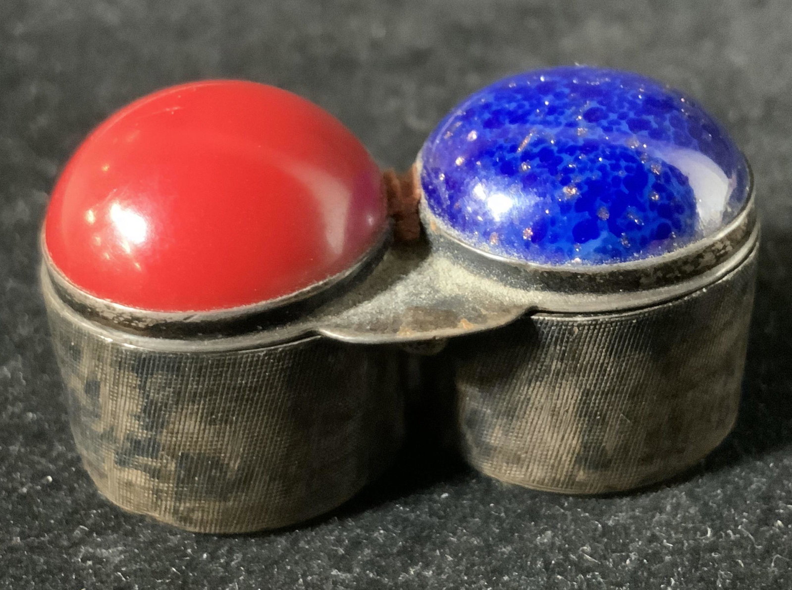 Signed Vintage GUCCI Metal Pill Box Vessel, Italy: Signed lidded metal vessel, possibly a pill case, with bezel set blue and red enamel stones. Lid needs repair, but can be closed. Underside marked Italy, Gucci. 125 (nickel). Approx. 1.5 in. length. A