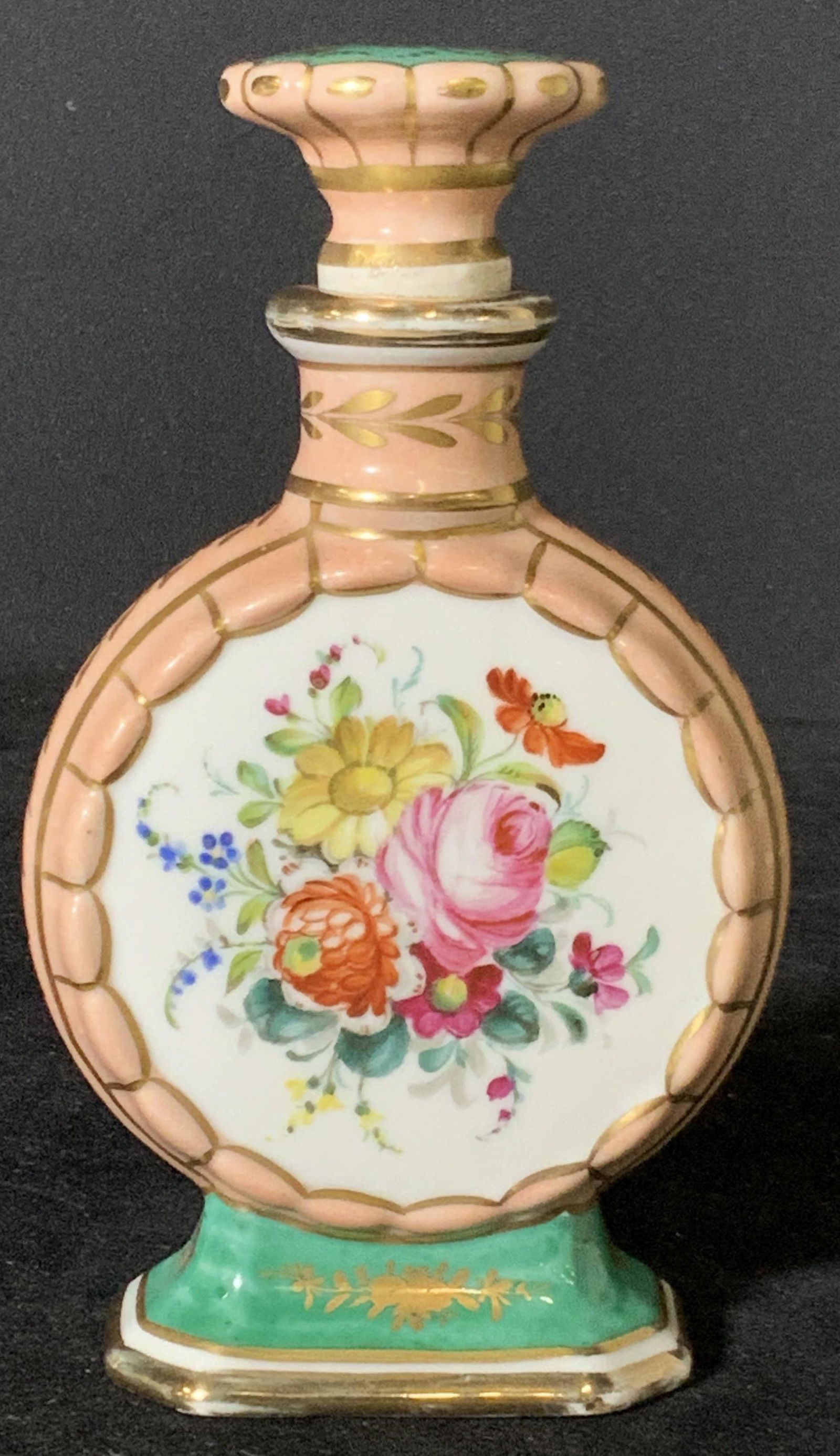 Vintage French Porcelain Perfume Bottle: Vintage, possibly French antique, porcelain perfume bottle. Hand painted gilt line work throughout bottle. Embossed porcelain along center. Center depicts array of flowers. Pink, green, and more color