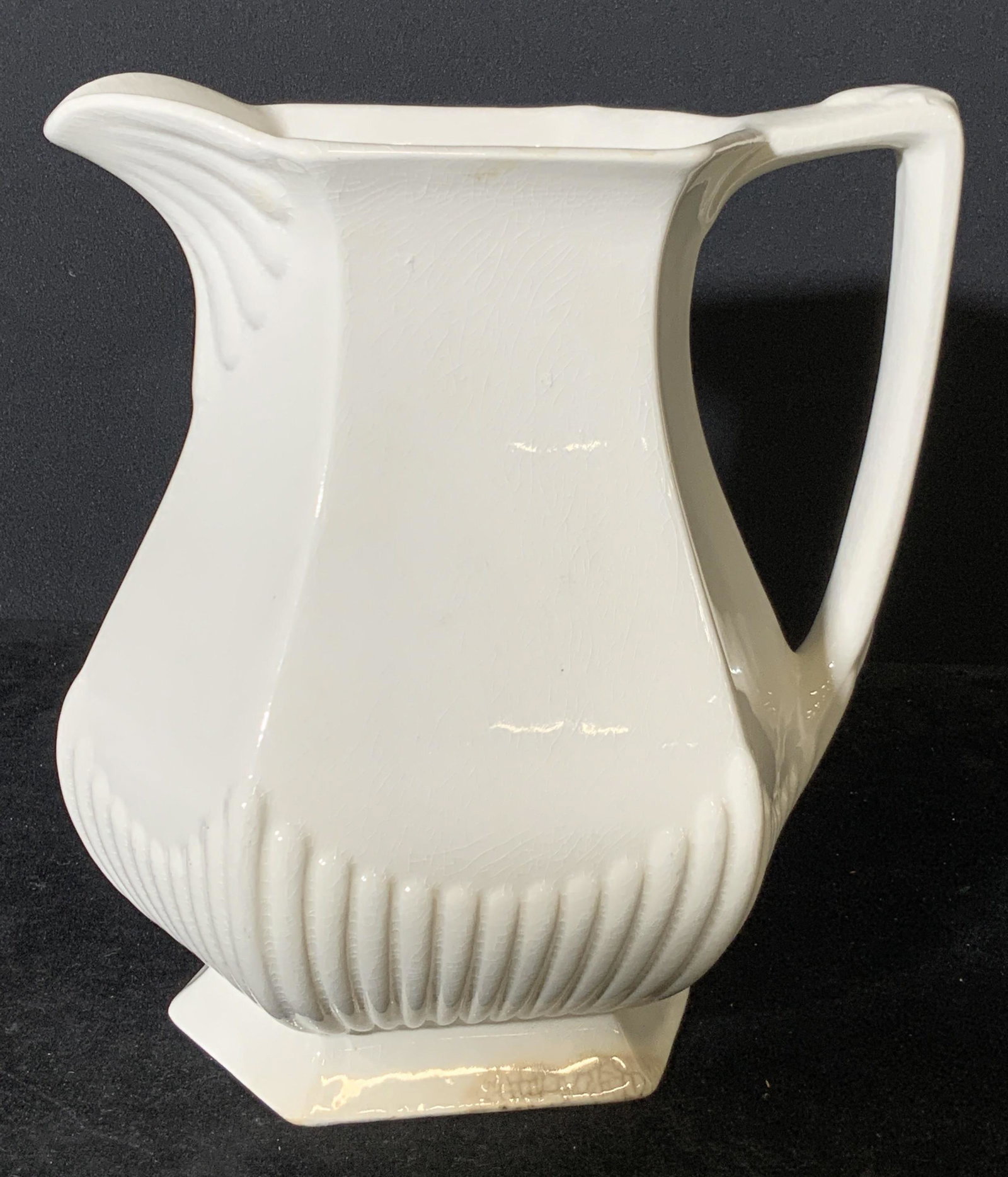 Vintage ADAMS & SONS Ironstone Pitcher, England: White ironestone pitcher with embossed porcelain designs along base and spout. Underside stamped: Real English Ironstone. WM ADAMS & SONS, England. Crazing throughout, vintage condition consistent wit