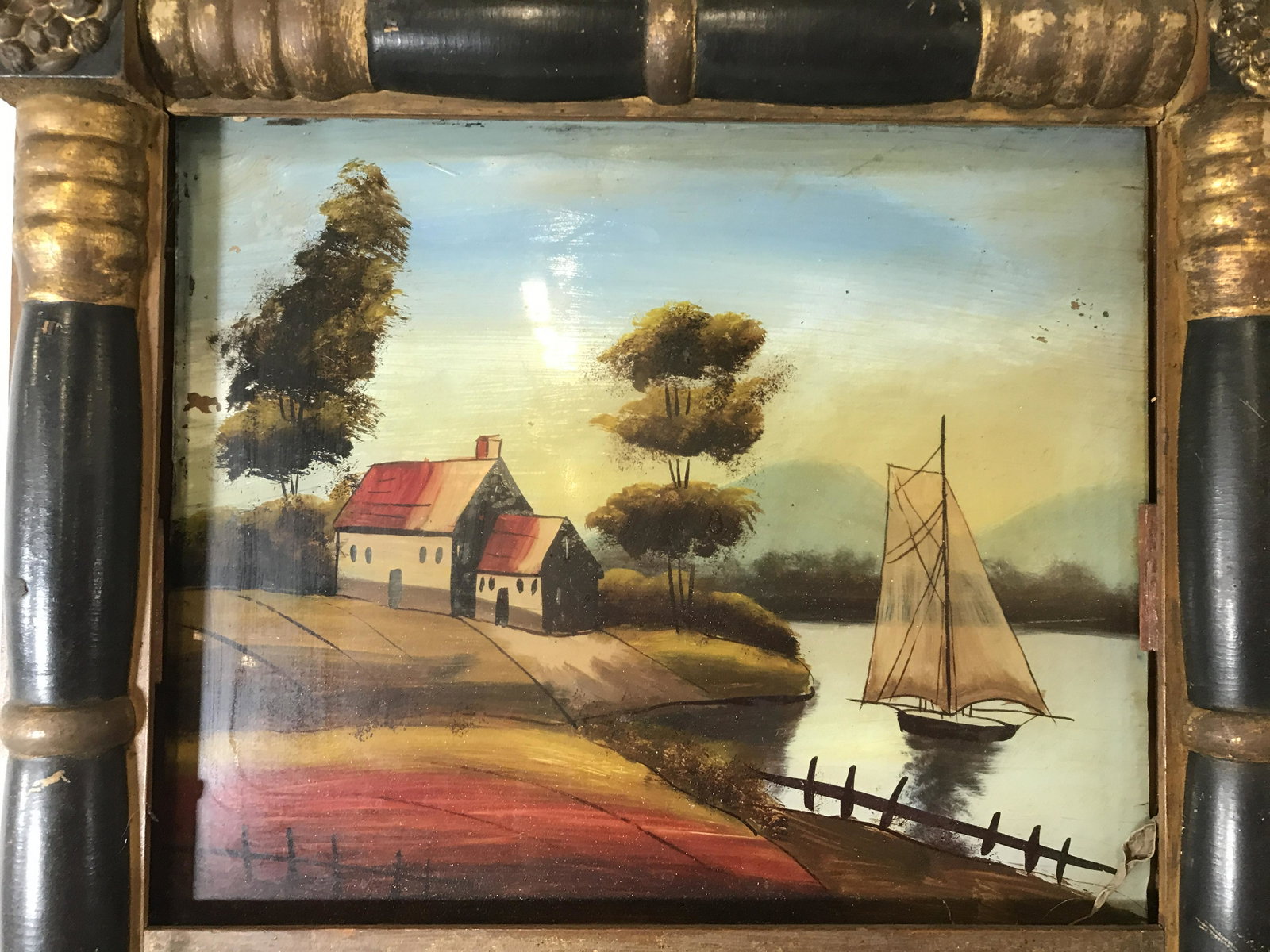 Vintage Pier Mirror w Painted Glass: Vintage, possibly antique, multi toned pier mirror. Flower formed brass medallions decorate each corner of the mirror. Mirror is black and gold toned. Painted glass depicts a lakefront property and sa