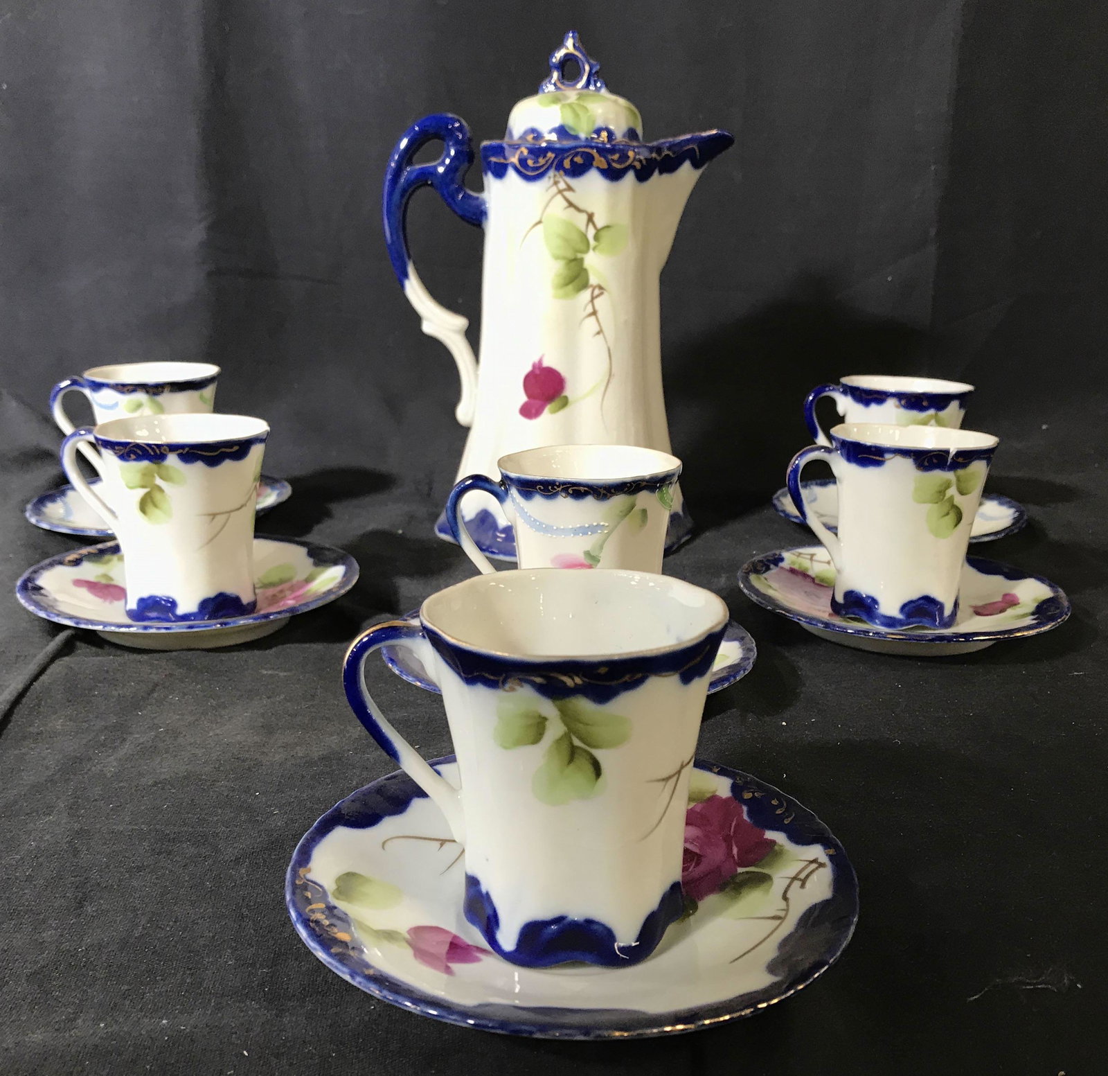 Set 13 NIPPON Hand Painted Partial China Set: Underside of saucers read NIPPON HAND PAINTED. Lot includes 6 saucers, 6 teacups, and 1 coffee pot. Each piece is hand painted with multi toned floral and leaf detail. Coffee pot measures approximatel