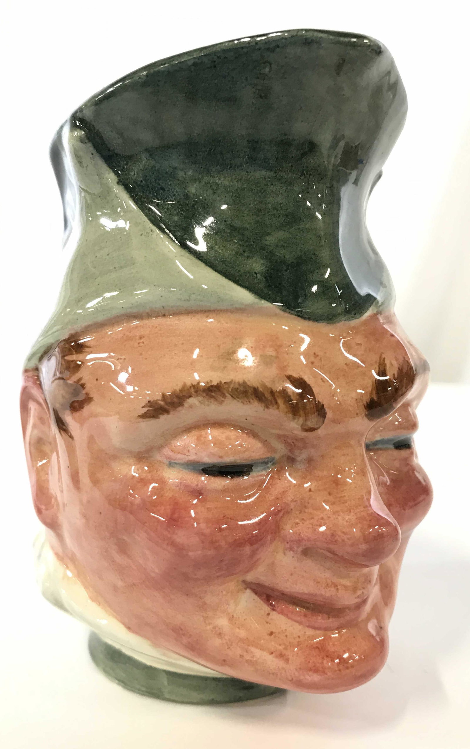 LANCASTER SANDLAND PUCK Cream Pitch: Underside is marked LANCASTER SANDLAND PUCK HAND PAINTED IN ENGLAND. Creamer appears to be porcelain. Piece has male head figure as structure of piece. Piece measures approximately 5.5 inches tall 5 i