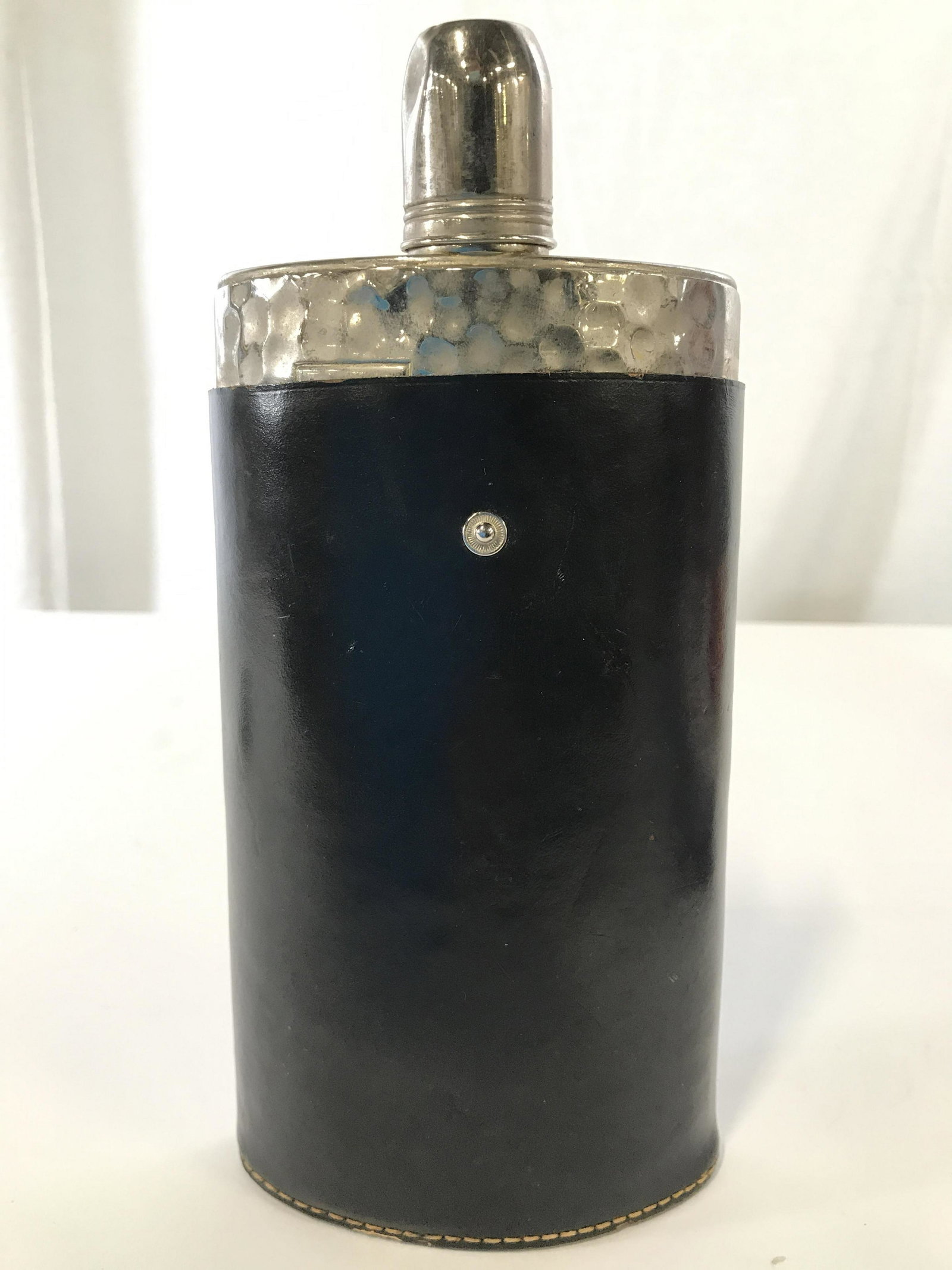 German Metal Flask W Leather Covering: Glas is silver toned and metal. Piece has black toned leather covering which is marked MADE IN GERMANY GENUINE COWHIDE. Piece measures approximately 8.5 inches tall 5 inches wide. Flask, barware, coll