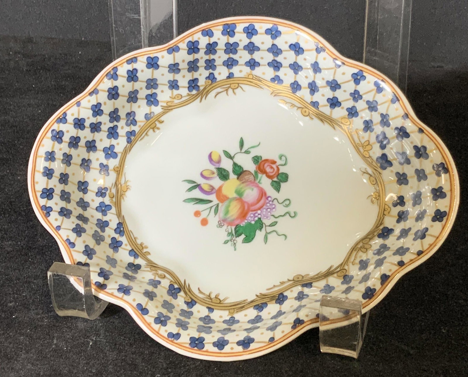Signed Vintage MOTTAHEDEH Porcelain Trinket Dish: Floral & fruit motif porcelain trinket dish with gilt line work and blue flower pattern throughout. Scalloped edges. Underside stamped: Mottahedeh. VA 1824. Portugal. Underside has 4 circular fabric c