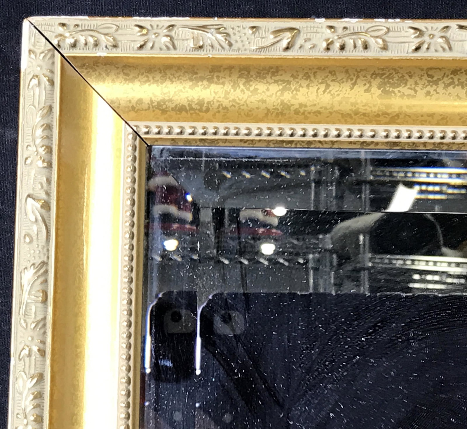 Hand Carved Gilt Wood Mirror: Hand Carved Gilt Wood Mirror, no apparent labels of stamps, hand carved gilt wood frame with vine designs carved into it, some sticker residue to surface of mirror, frame needs tightening at corners, 
