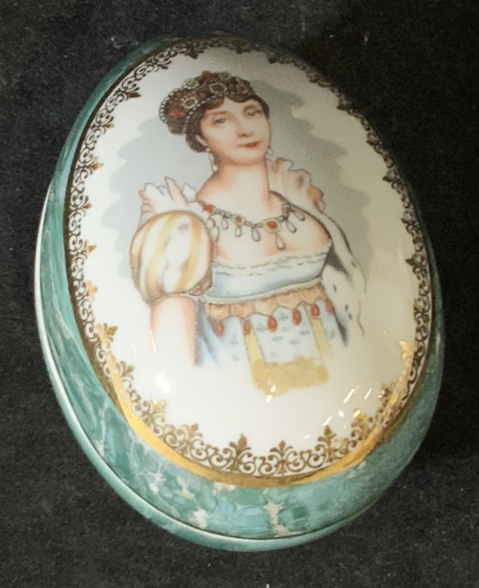 Signed LIMOGES Porcelain Trinket Box, France: Egg shaped lidded porcelain trinket box with a painted portrait of a woman, Josephine, on the lid. Gilt line work, blue-green coloring throughout. Underside signed: Limoges, France. Approx. height 3 i