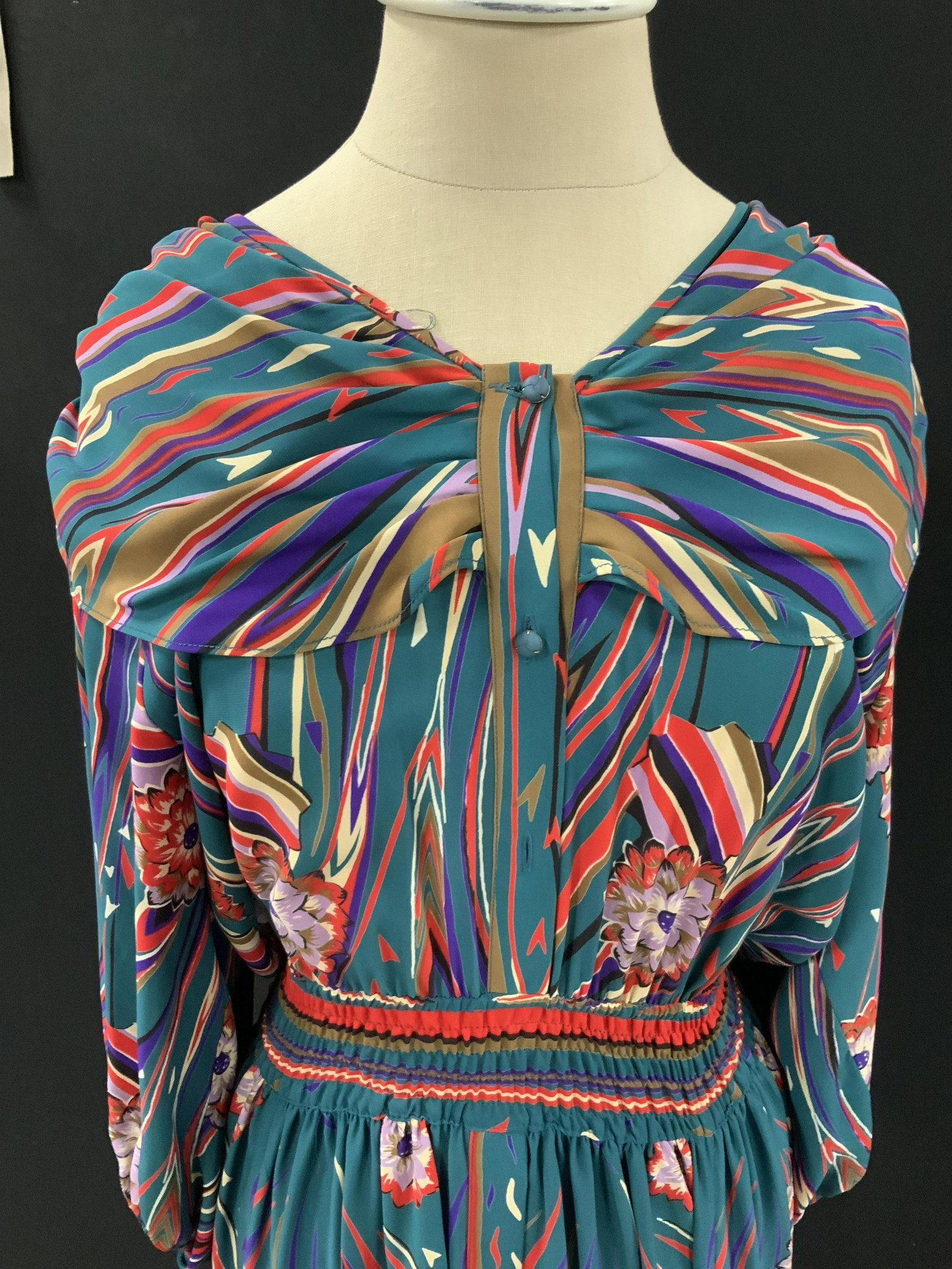 DIANE FREIS Blue Patterned Knee Length Dress: Knee length red & black patterned dress. Button up, 8 blue buttons. Missing one button. Patterns include horizontal red, white, & purple stripes and florals. Shoulder pads. Cinched waist and sleeves. 