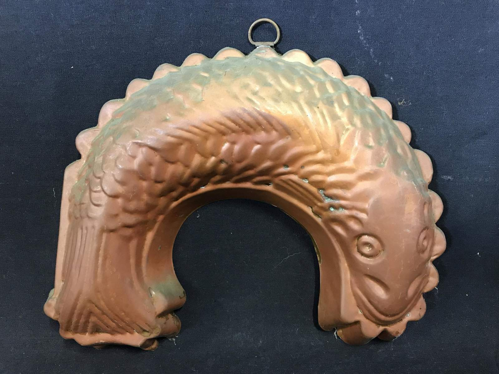 Antique Copper Cake / Jello Mold: Antique copper mold, resembles a fish, the fish is curled. A metal ring is affixed to the mold, allowing for storage and hanging. Measures approx 10 inches H, and 11 inches long. Wear is consistent wi