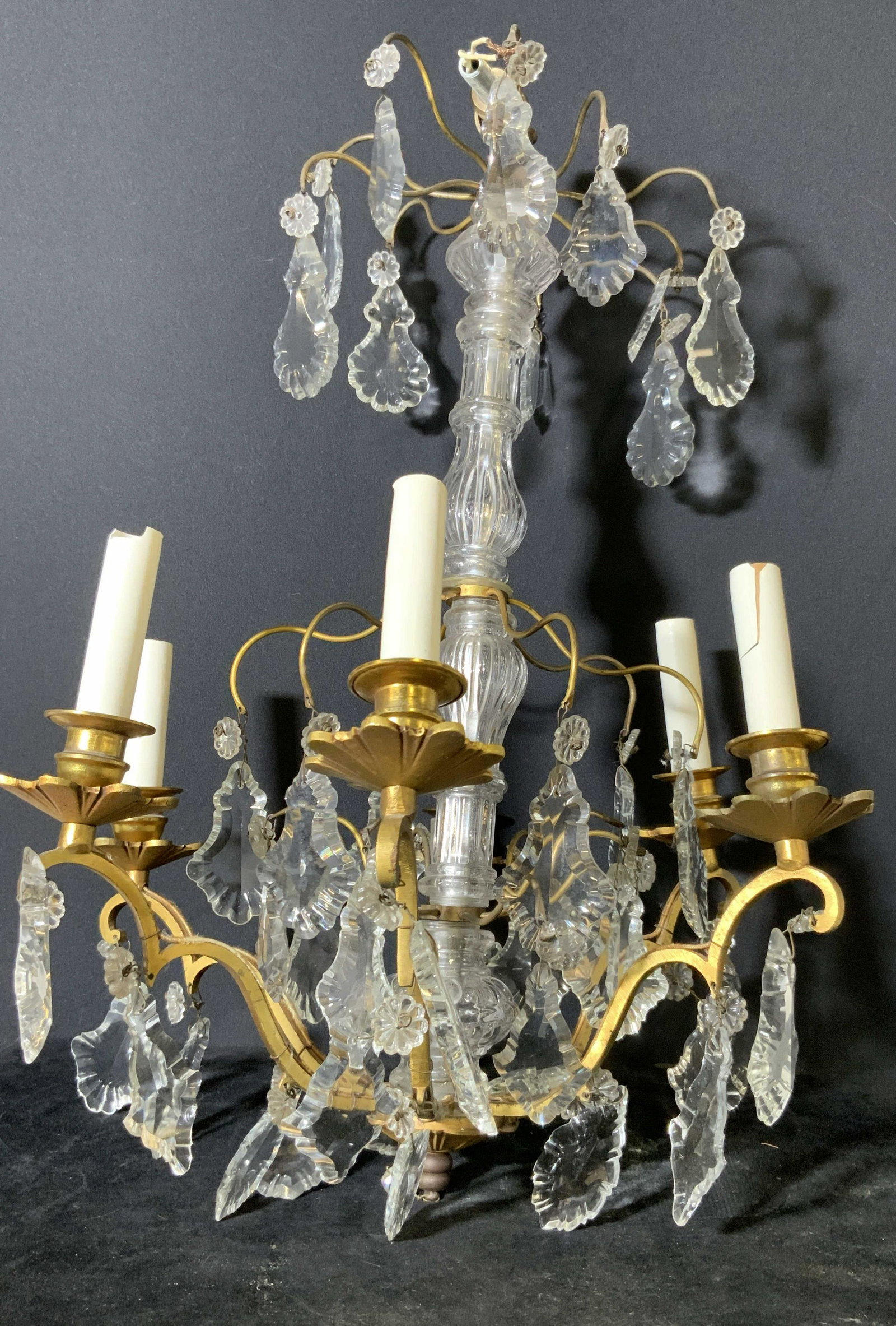 Antique Metal Art Glass Chandelier: Possibly antique metal chandelier with decorative art glass hanging Prisms, Art glass is floral shaped & geometric. Gold toned metal. 6 arms for lighting. Untested. Approx. 21 in. height. Approx. 13 i