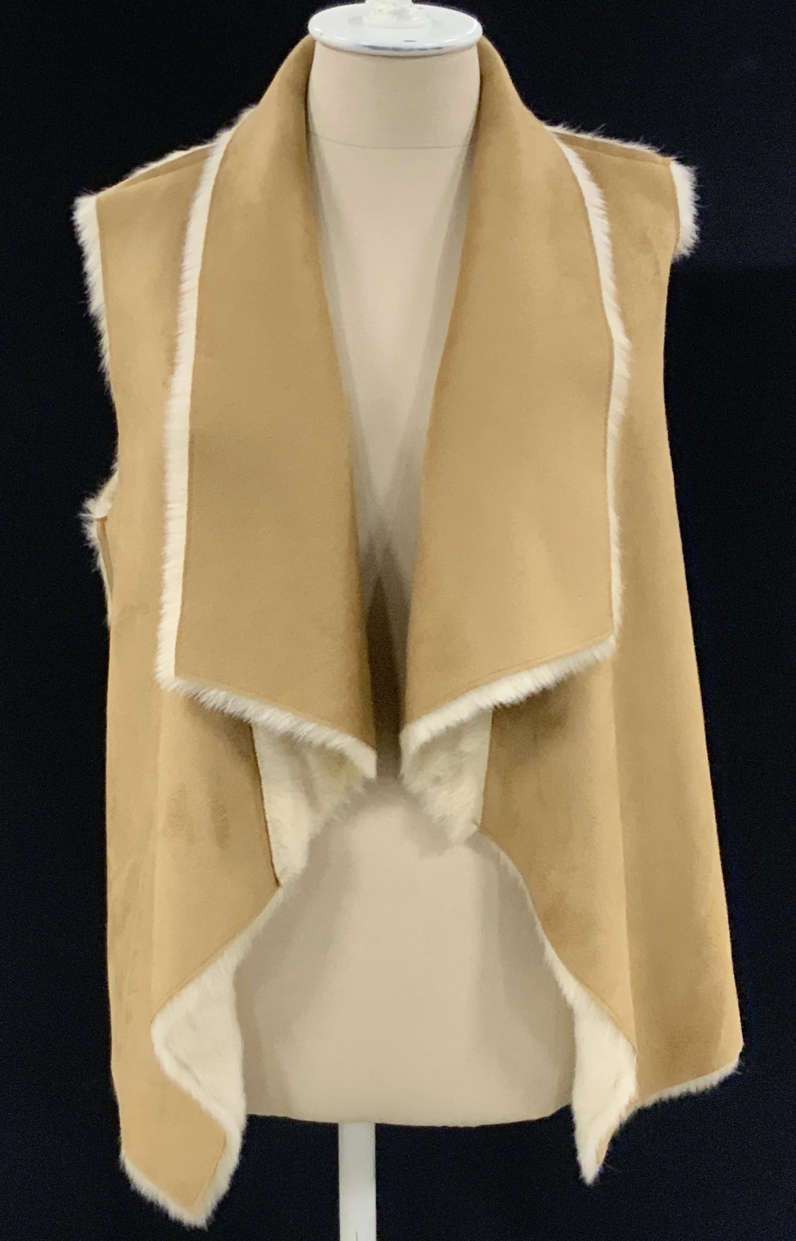 Faux Fur & Suede Women’s Vest: Likely faux fur & suede women’s sleeveless vest. Light brown hues. Interior lined w/ faux fur. Two exterior textile lined pockets. Approx. size L. Length approx. 23 in. Faux fur fashion, faux fur ve