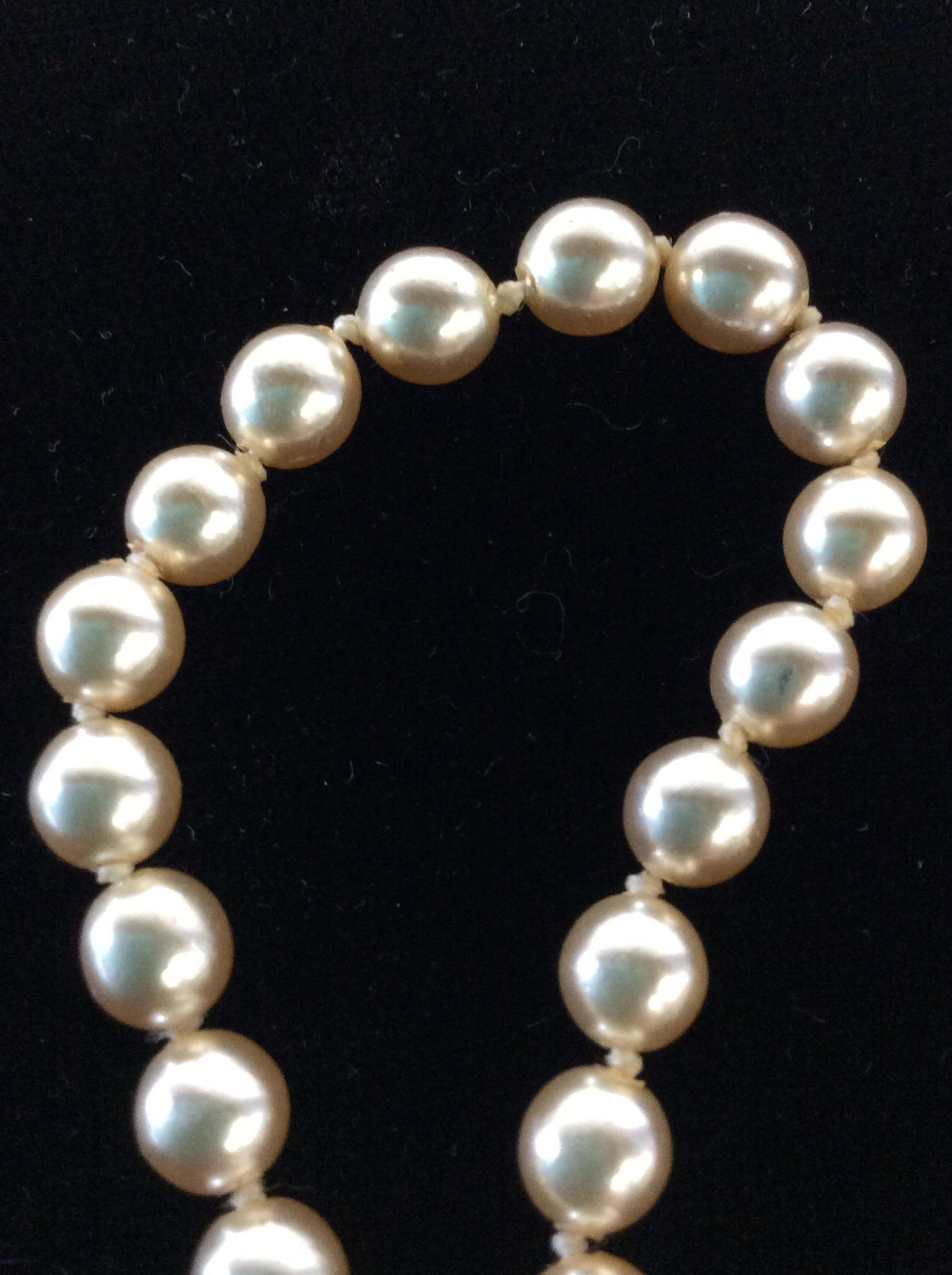Nolan Miller Champagne Pearl Bracelet: Hand Strung 4 mm pearls, possibly cultured, decorative clasp crystal & solitaire pearl in gold tone metal, push snap clasp, 7 3/8 in. Signed Nolan Miller on reverse side of clasp. Designer Nolan Mille